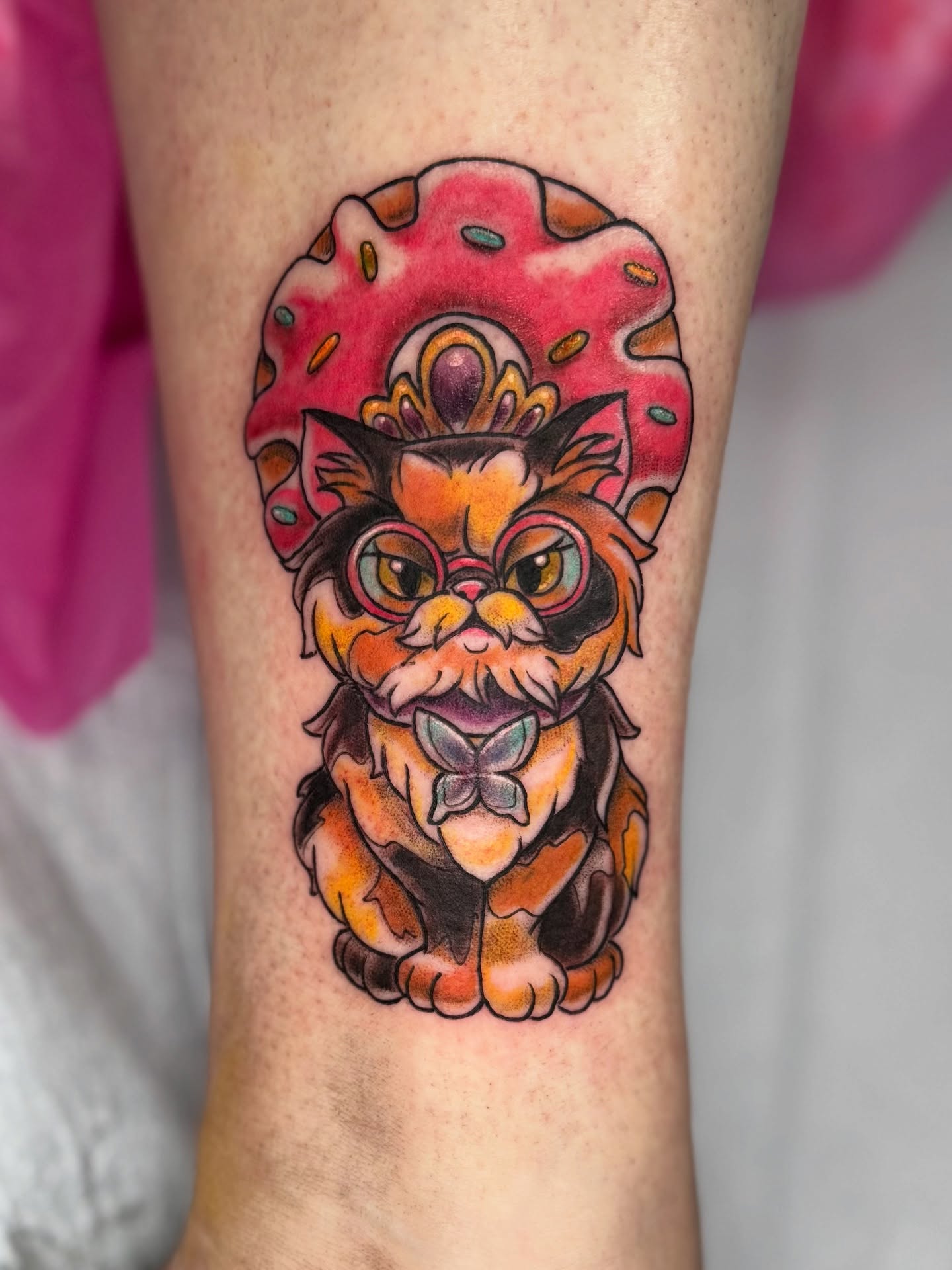 Cat with donut crown American traditional tattoo on the forearm by Breanna B