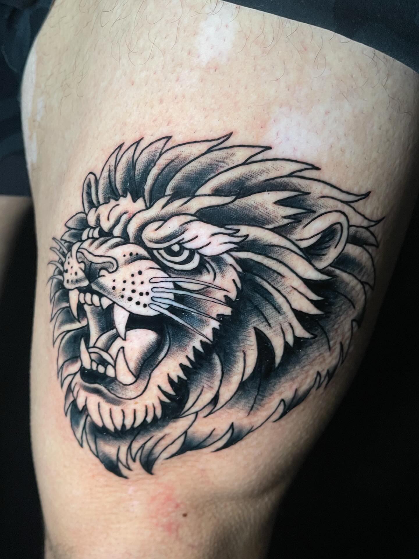 Lion black and grey tattoo on the thigh by Josh Brownell