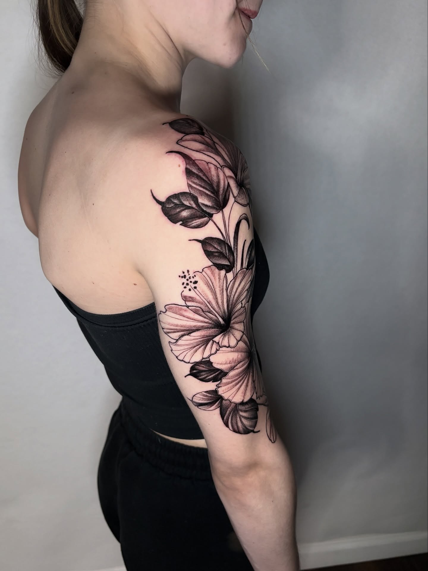 Flower black and grey tattoo on the upper arm by Tony Lucero, Wheat Ridge, Colorado