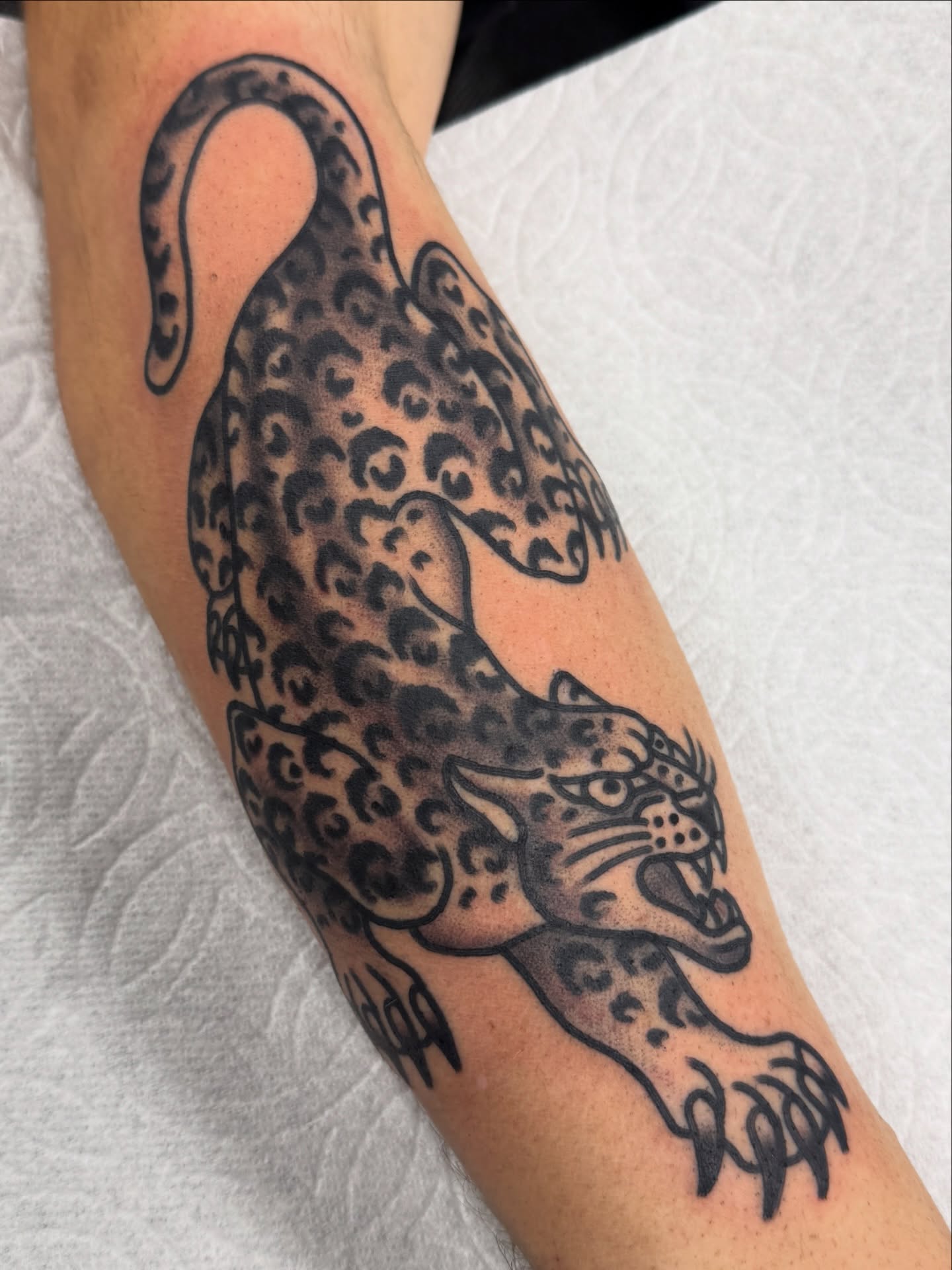 Leopard black and grey tattoo on the forearm by Joey Burdette Tattoos