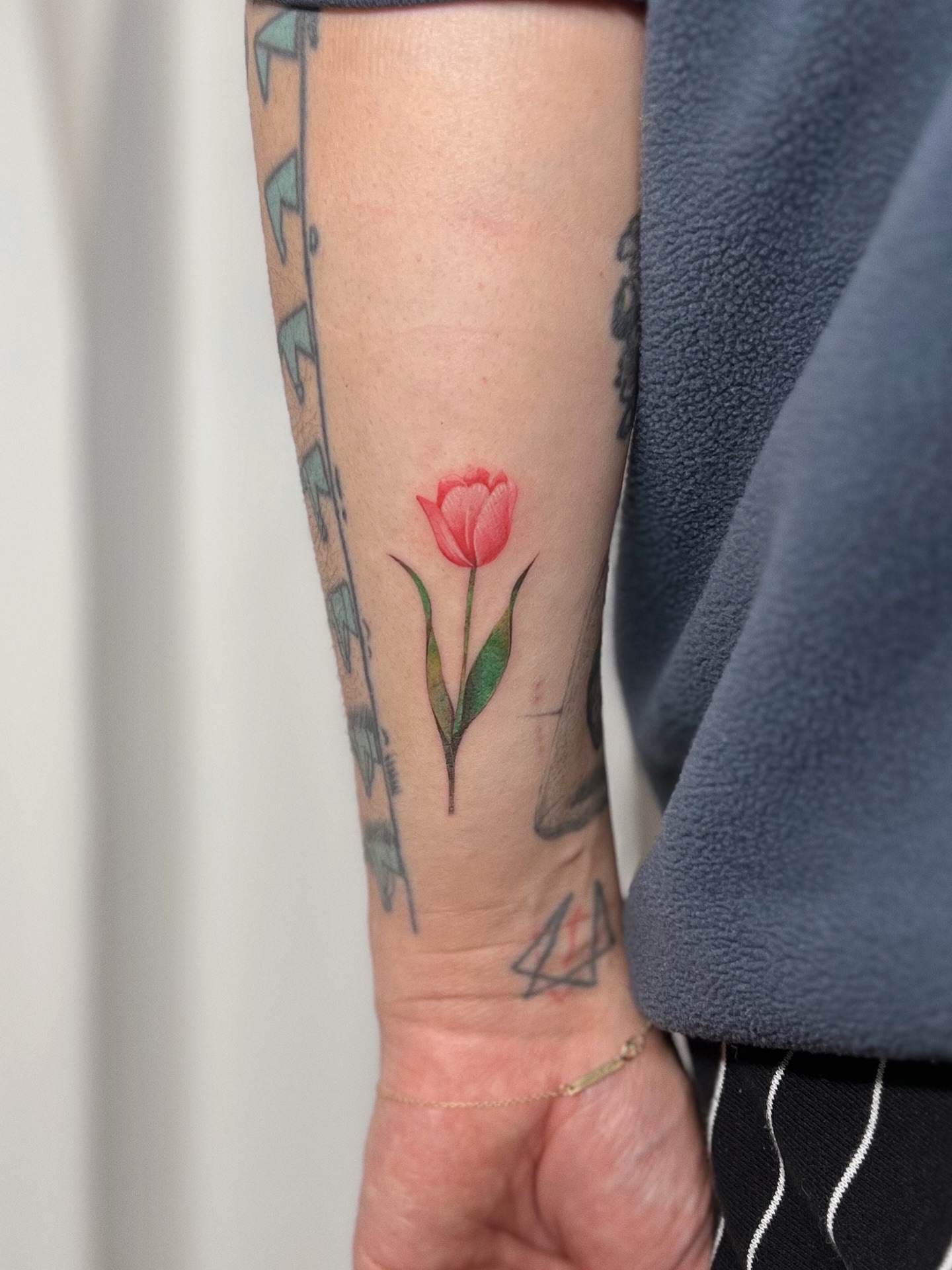 Red tulip realism tattoo on the forearm by Soy 🫛