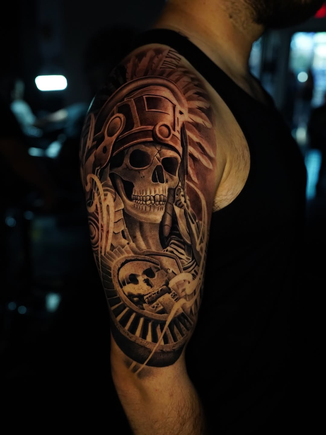 Skull in headdress with gear elements realism tattoo on the upper arm by Salvador Saenz Jr, Dallas, Texas