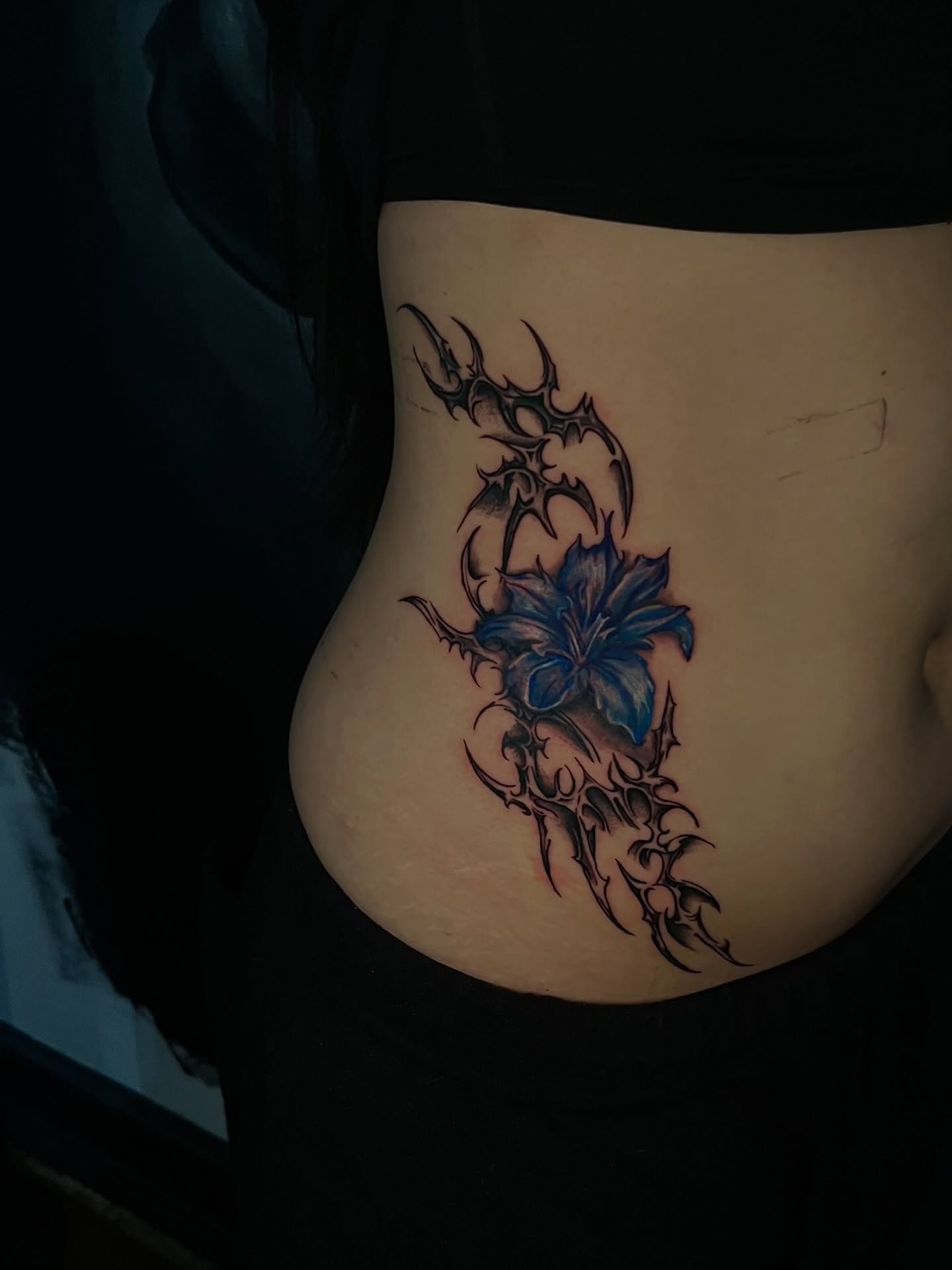 Blue lily with thorns tribal tattoo on the torso by Unknwn Ink ⭐️