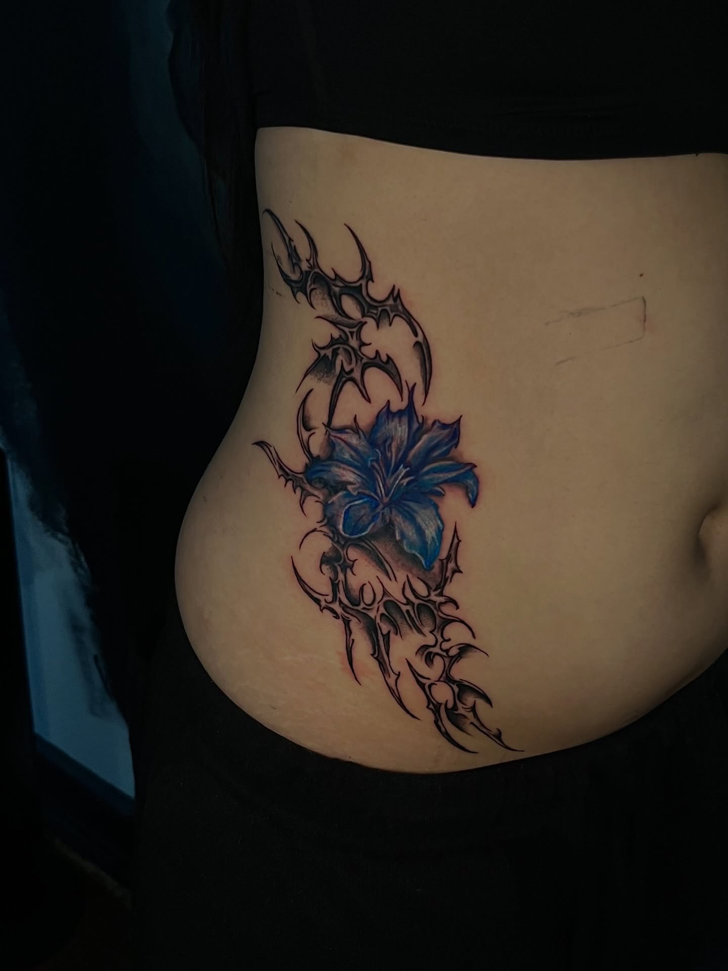 Blue lily with thorns tribal tattoo on the torso by Unknwn Ink ⭐️