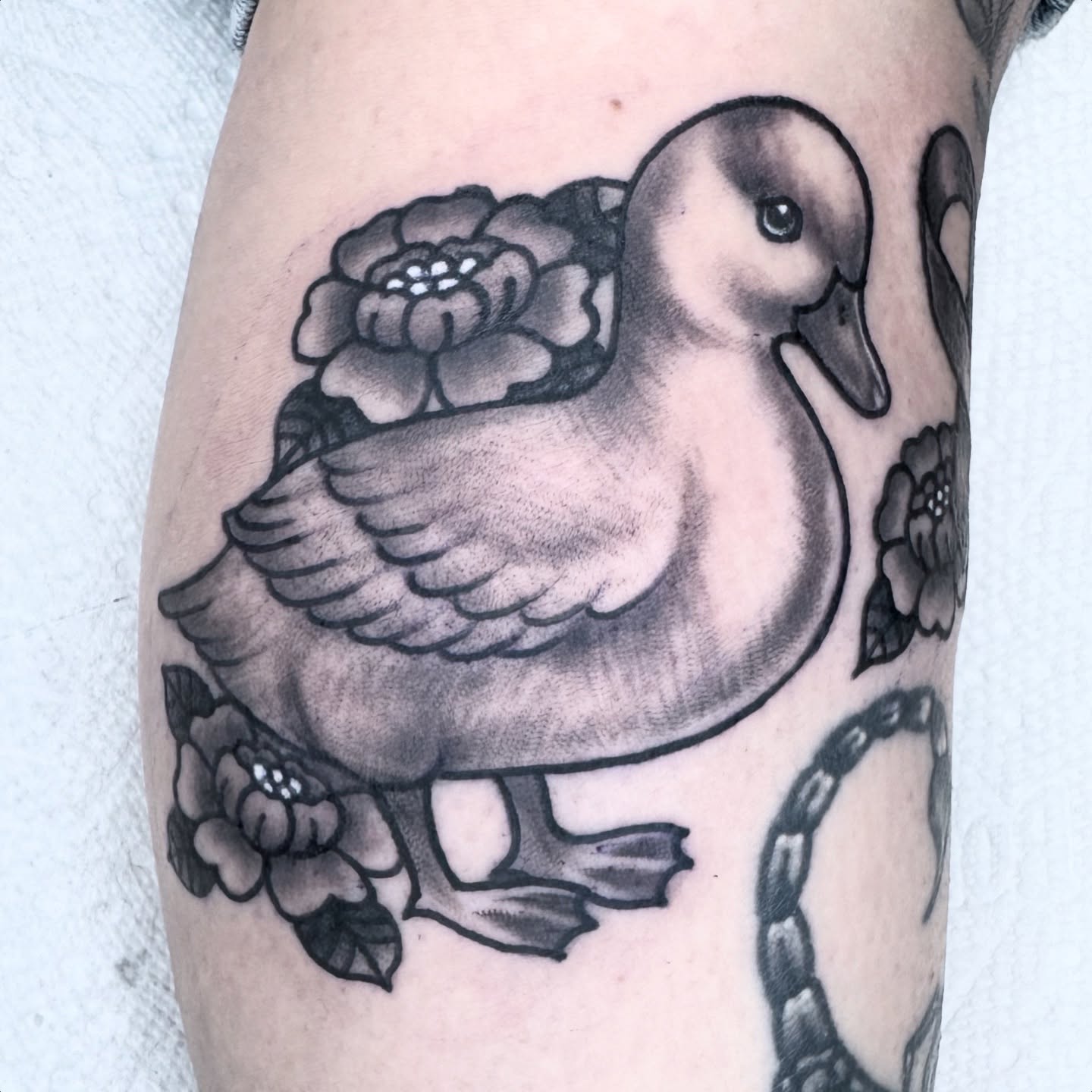 Duck with flowers black and grey tattoo on the forearm by Lisa Del Toro