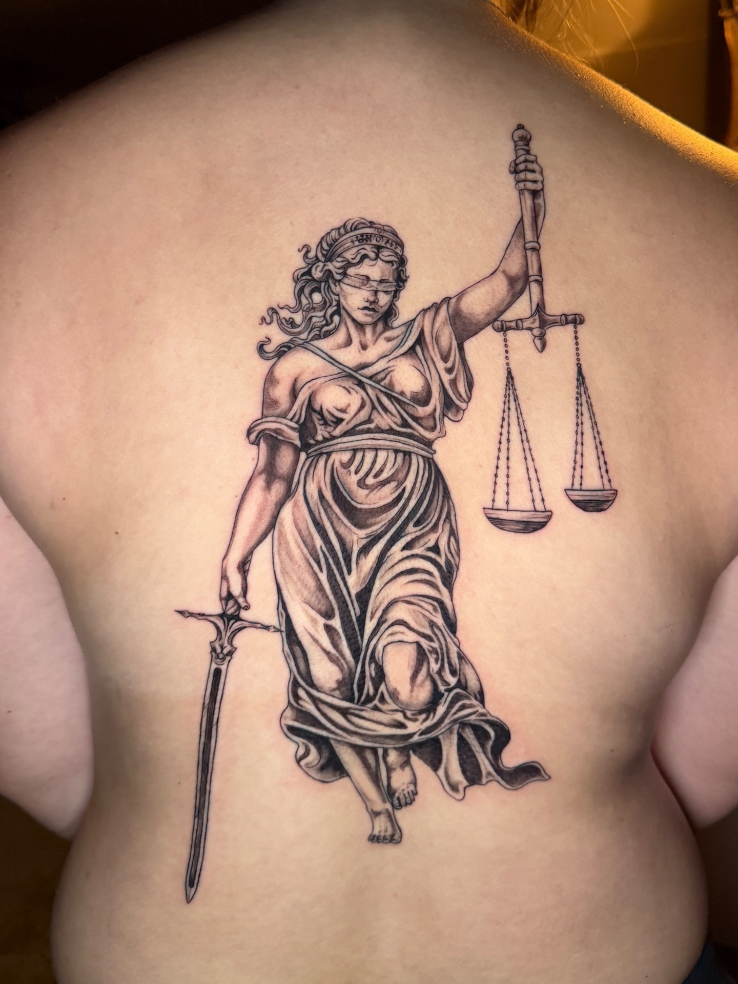 Lady Justice realism tattoo on the back by Quin Walker