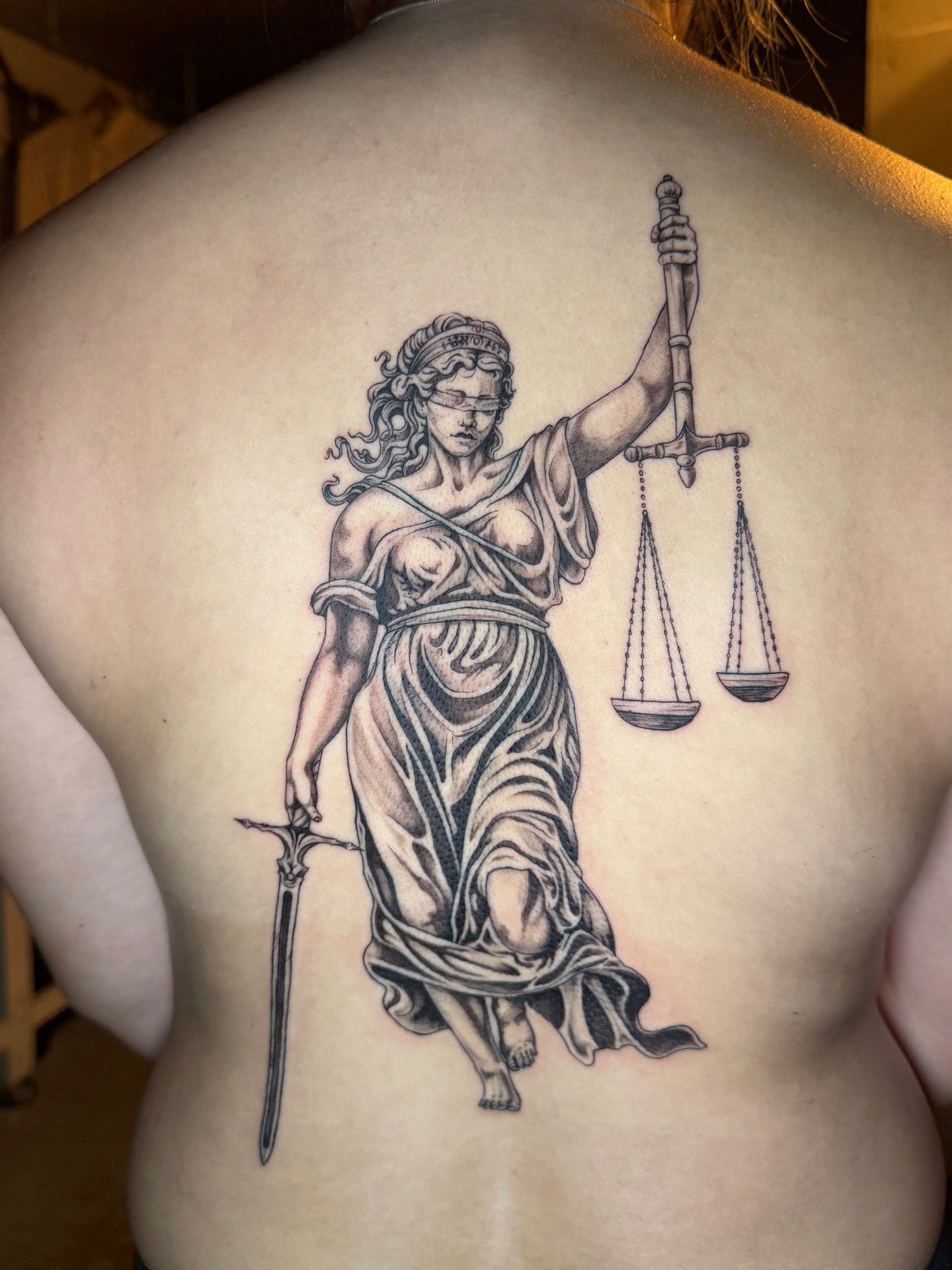 Lady Justice realism tattoo on the back by Quin Walker