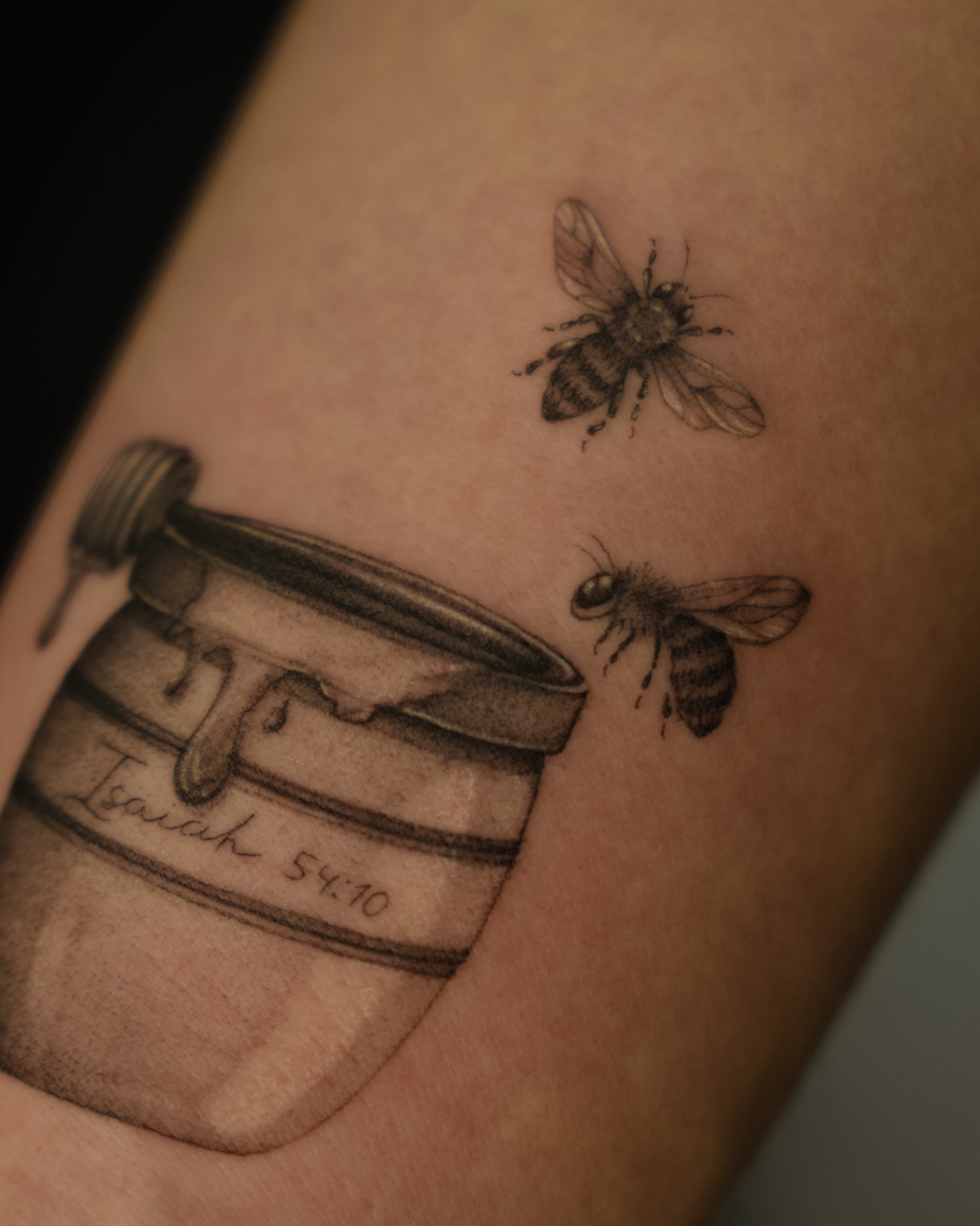 Bees and honey pot black and grey tattoo on the forearm by Laura Gomez Tattoos