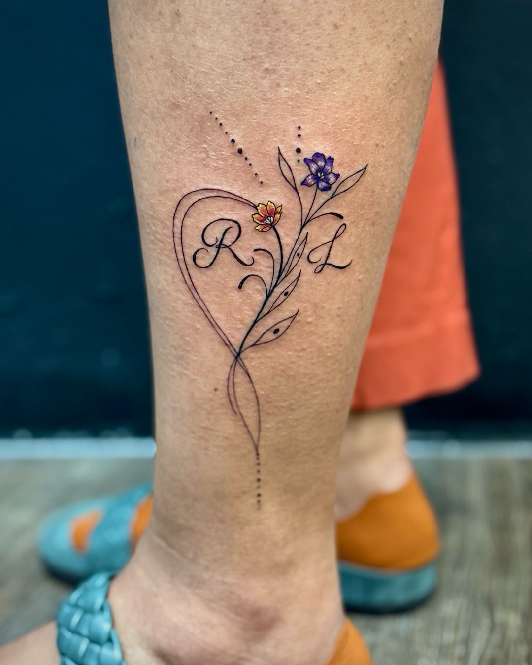 Heart with floral elements fine line tattoo on the calf by David