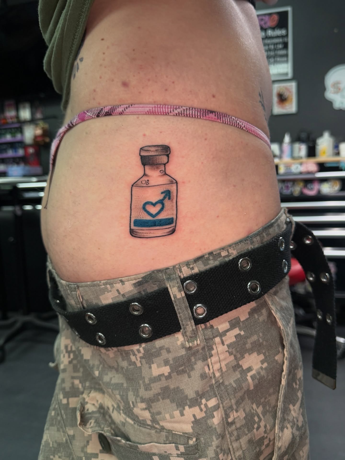 Medicine bottle with heart and arrow black and grey tattoo on the thigh by Erin Morbid