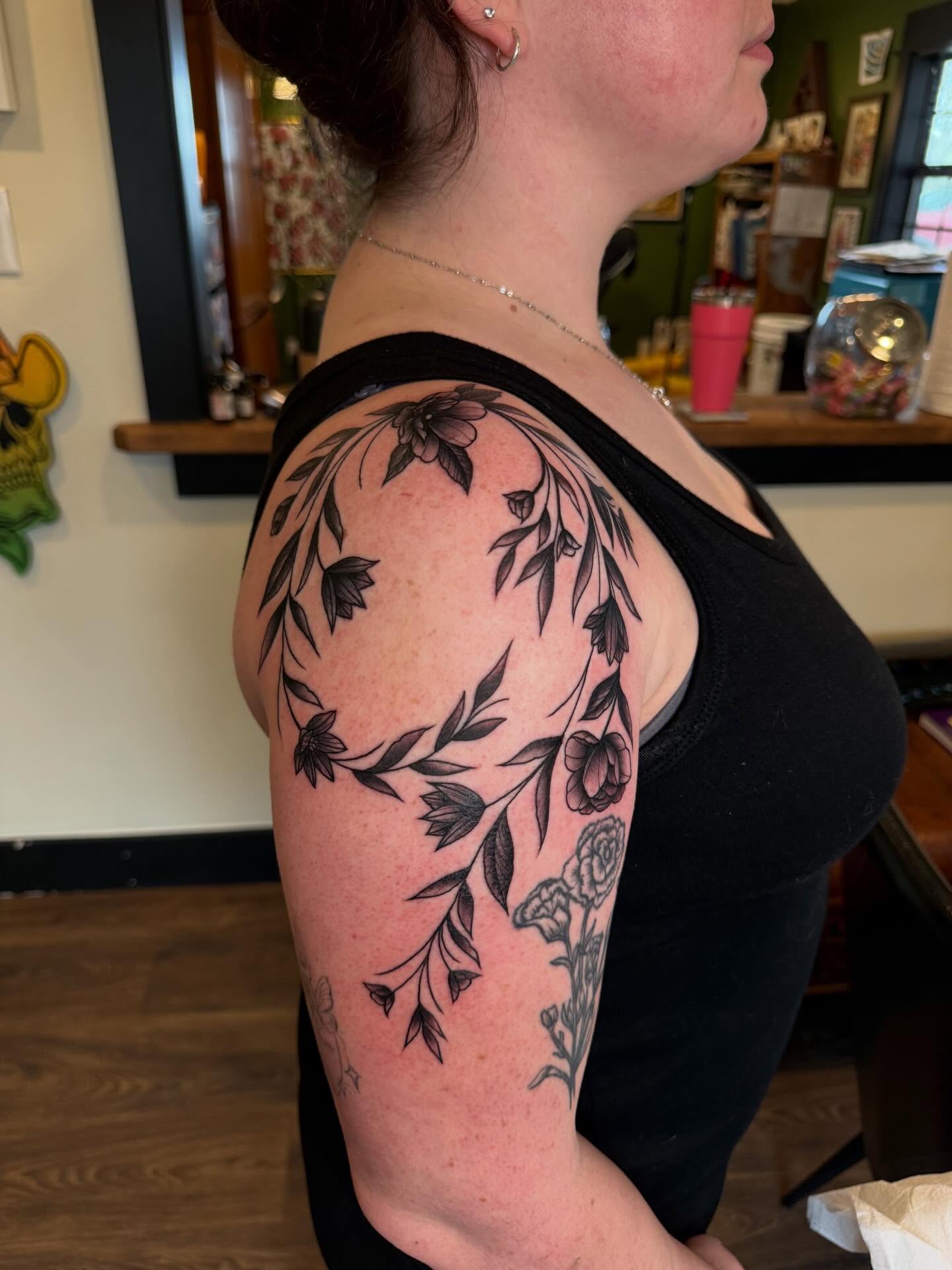 Floral wreath black and grey tattoo on the shoulder by Rebecca Basma Smith