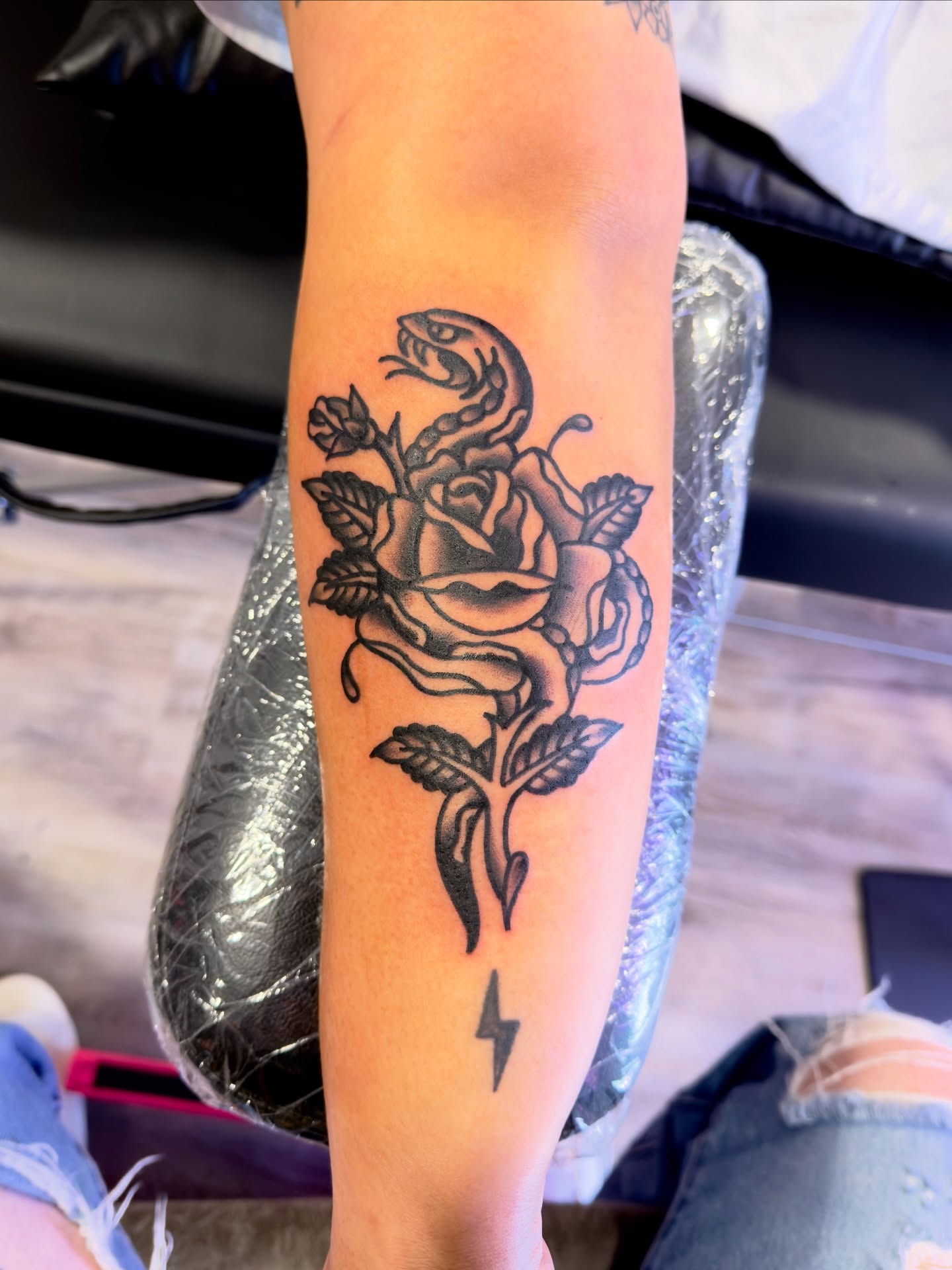 Snake and rose black and grey tattoo on the forearm by Jimmy Kelley