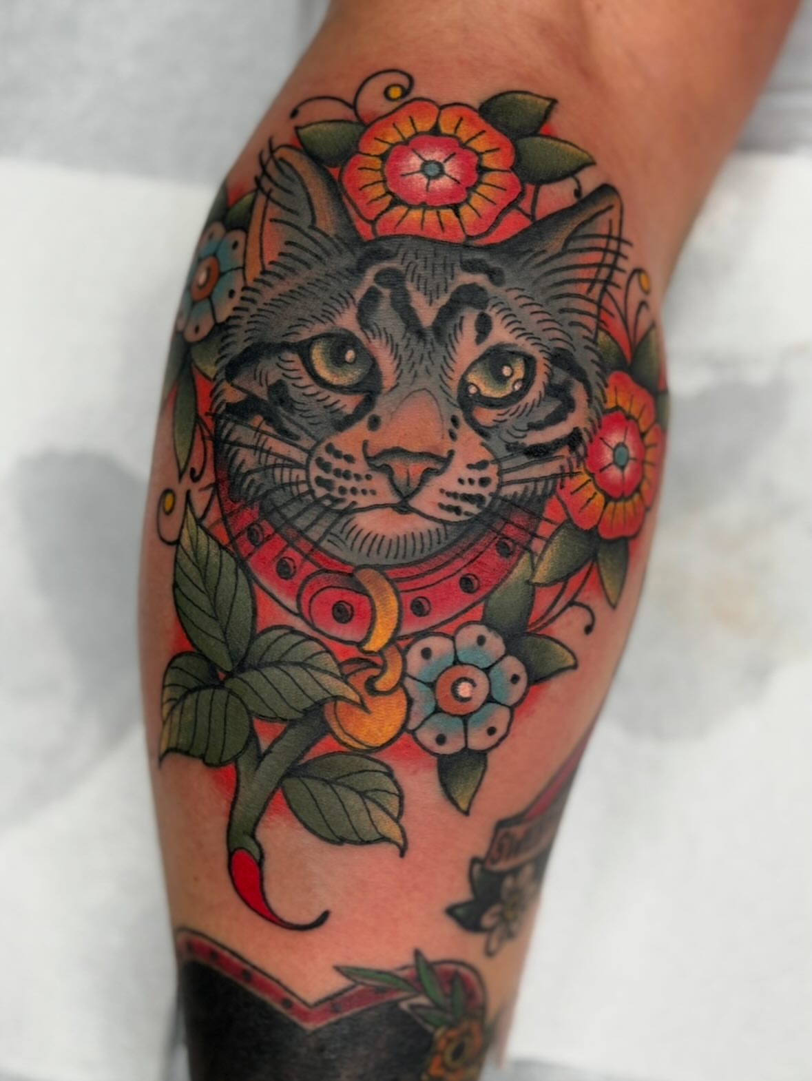 Cat with floral crown American traditional tattoo on the forearm by Cody Collins