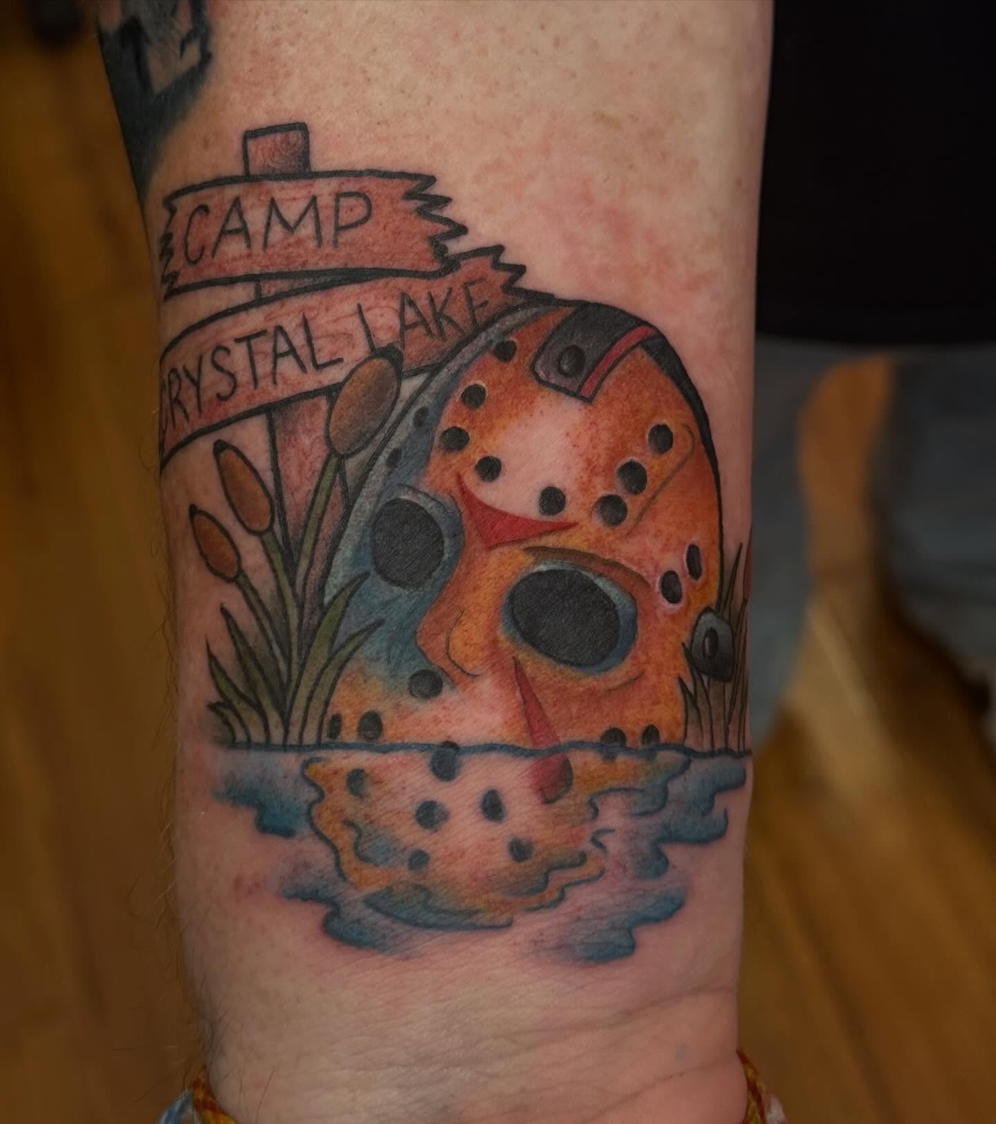 Camp Crystal Lake trash polka tattoo on the forearm by Madilynn Klassen