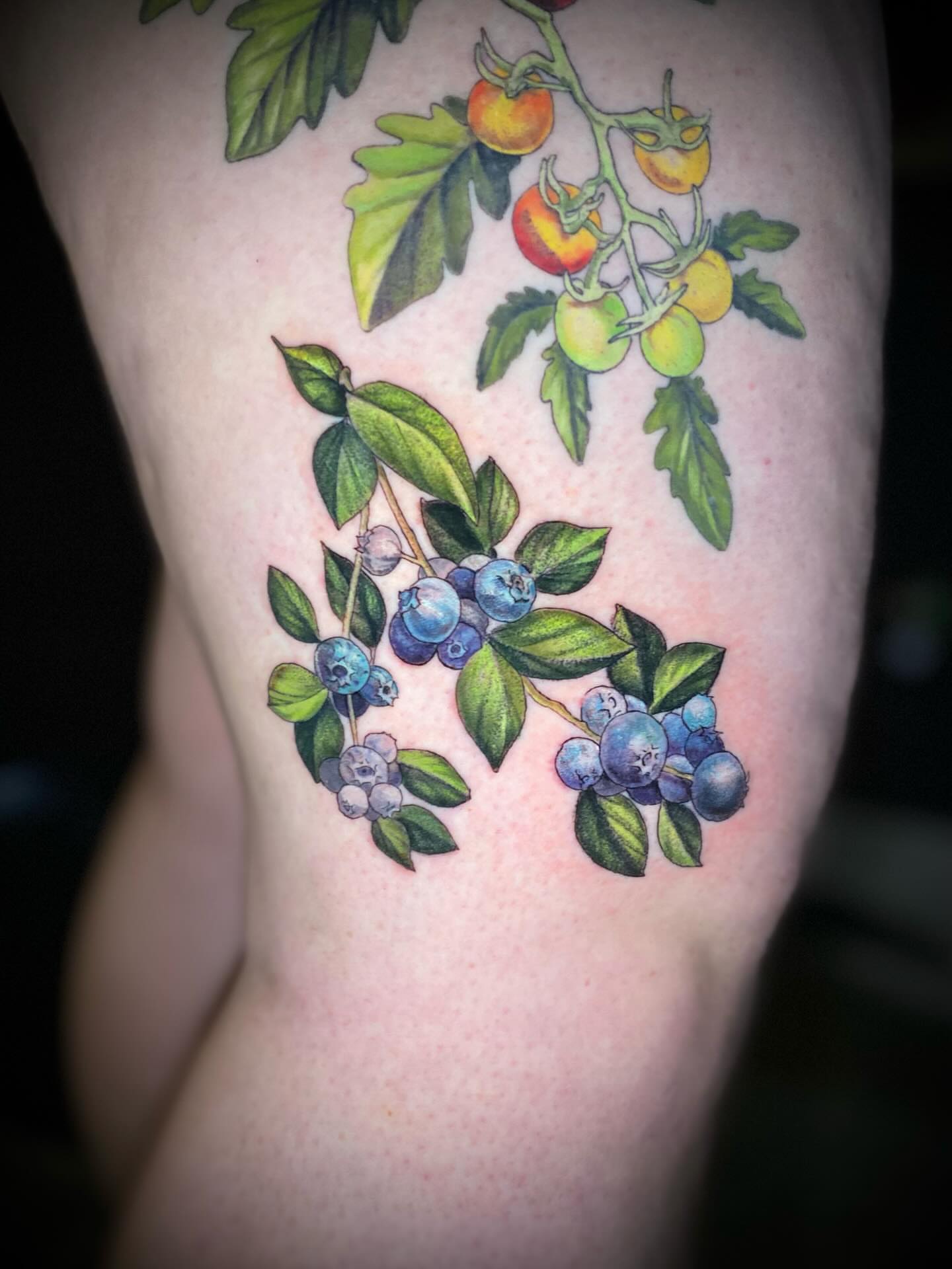 Blueberries and leaves realism tattoo on the thigh by Olivia Scott - Kansas Tattoo Artist