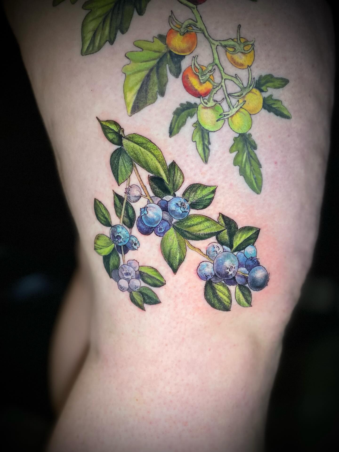 Blueberries and leaves realism tattoo on the thigh by Olivia Scott - Kansas Tattoo Artist