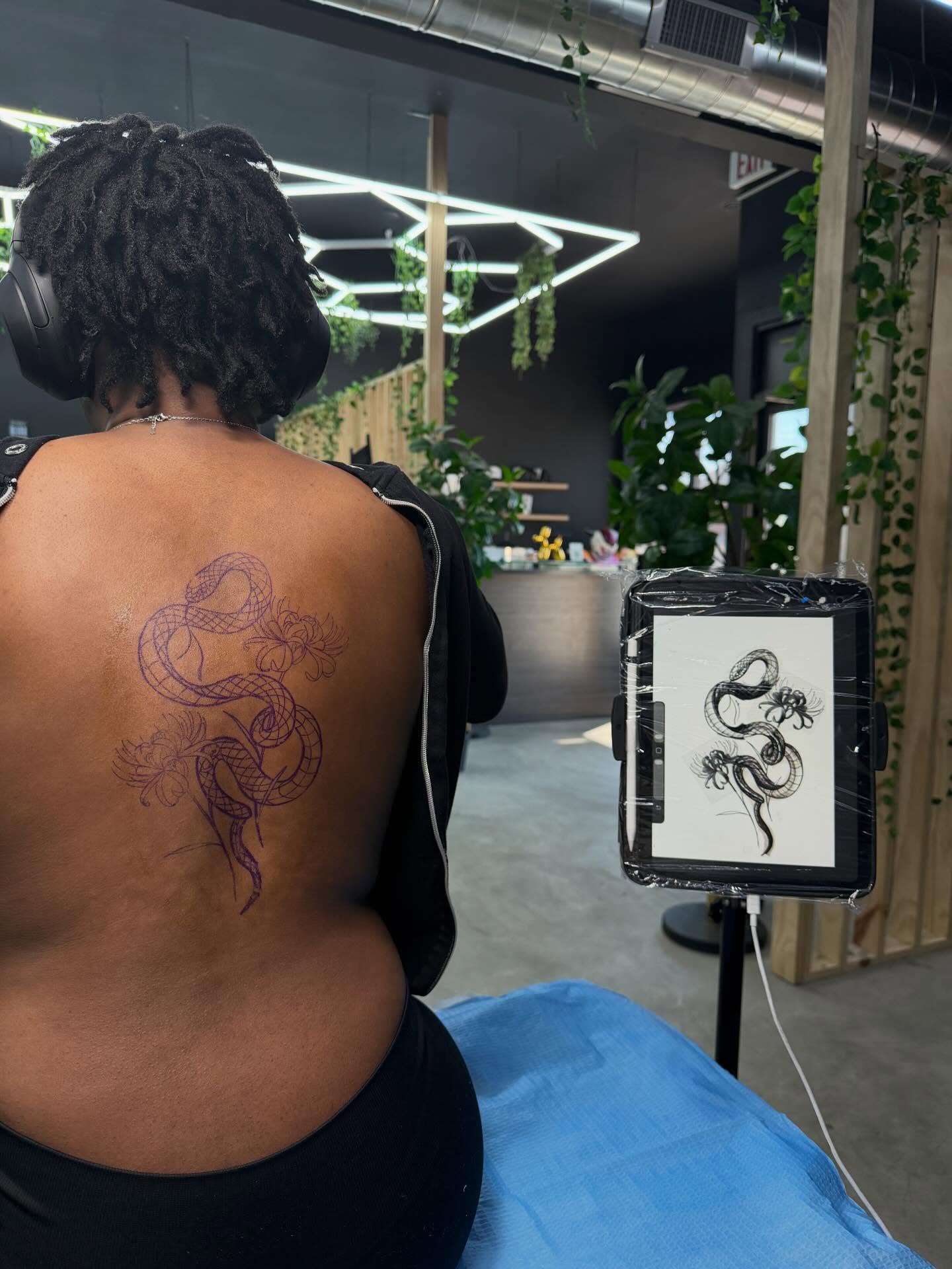 Snake and flowers American traditional tattoo on the back by Angela Azure