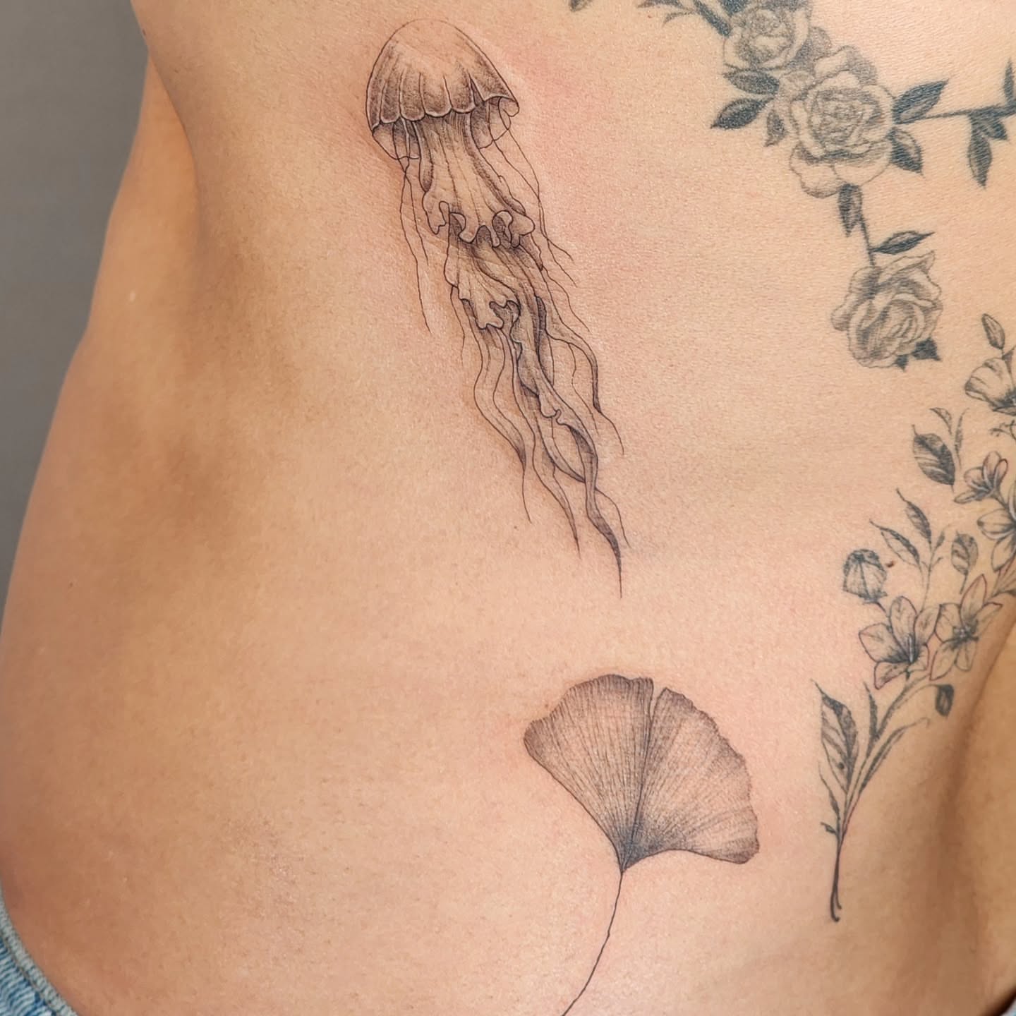 Jellyfish and ginkgo leaf realism tattoo on the ribs by Tattoo artist - Luciana Dsilva, San Francisco, California