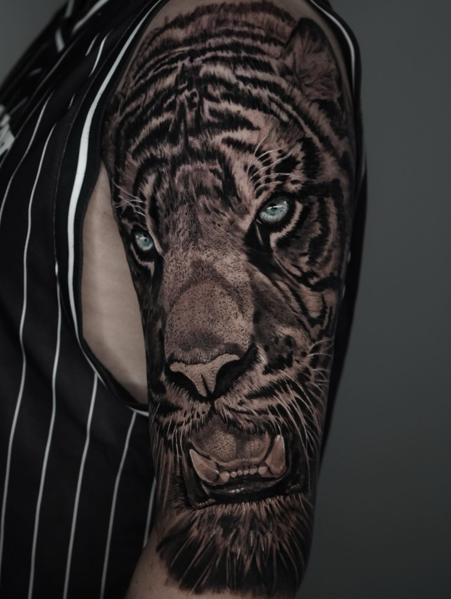 Tiger realism tattoo on the upper arm by Carlos Trujillo