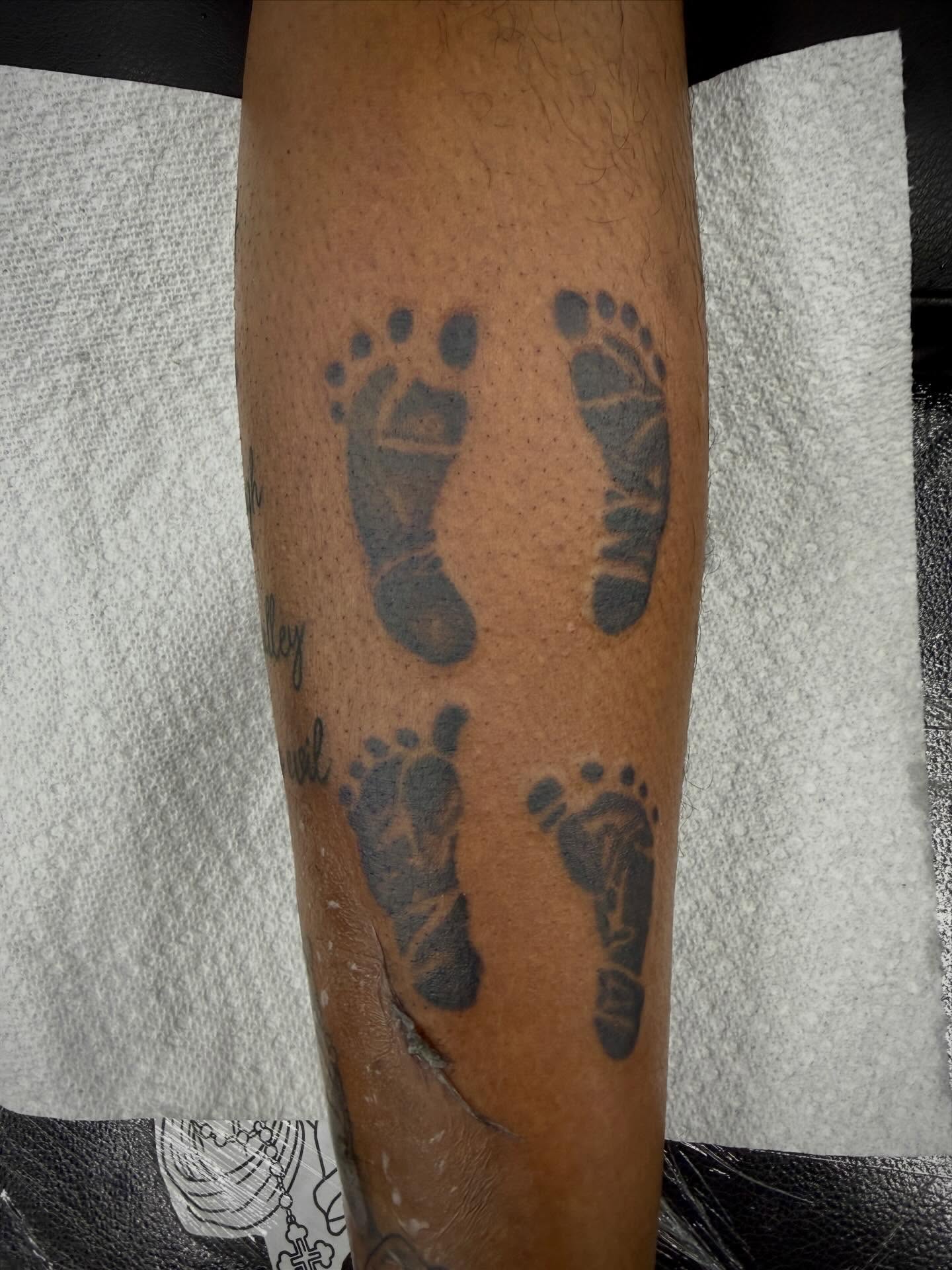 Footprints black and grey tattoo on the forearm by Ali Calis