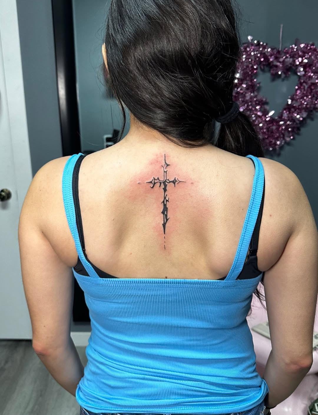 Ornate cross blackwork tattoo on the back by Lupita Ink