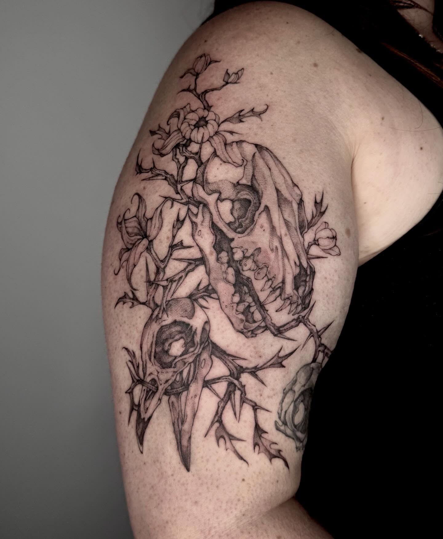 Skull and flowers realism tattoo on the shoulder by taline
