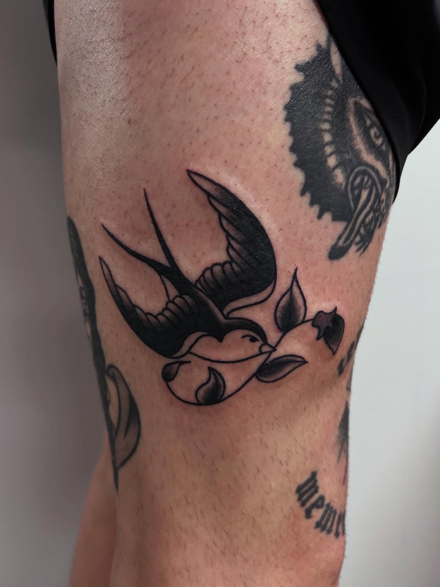 Swallow and leaves American traditional tattoo on the forearm by Brii Moser
