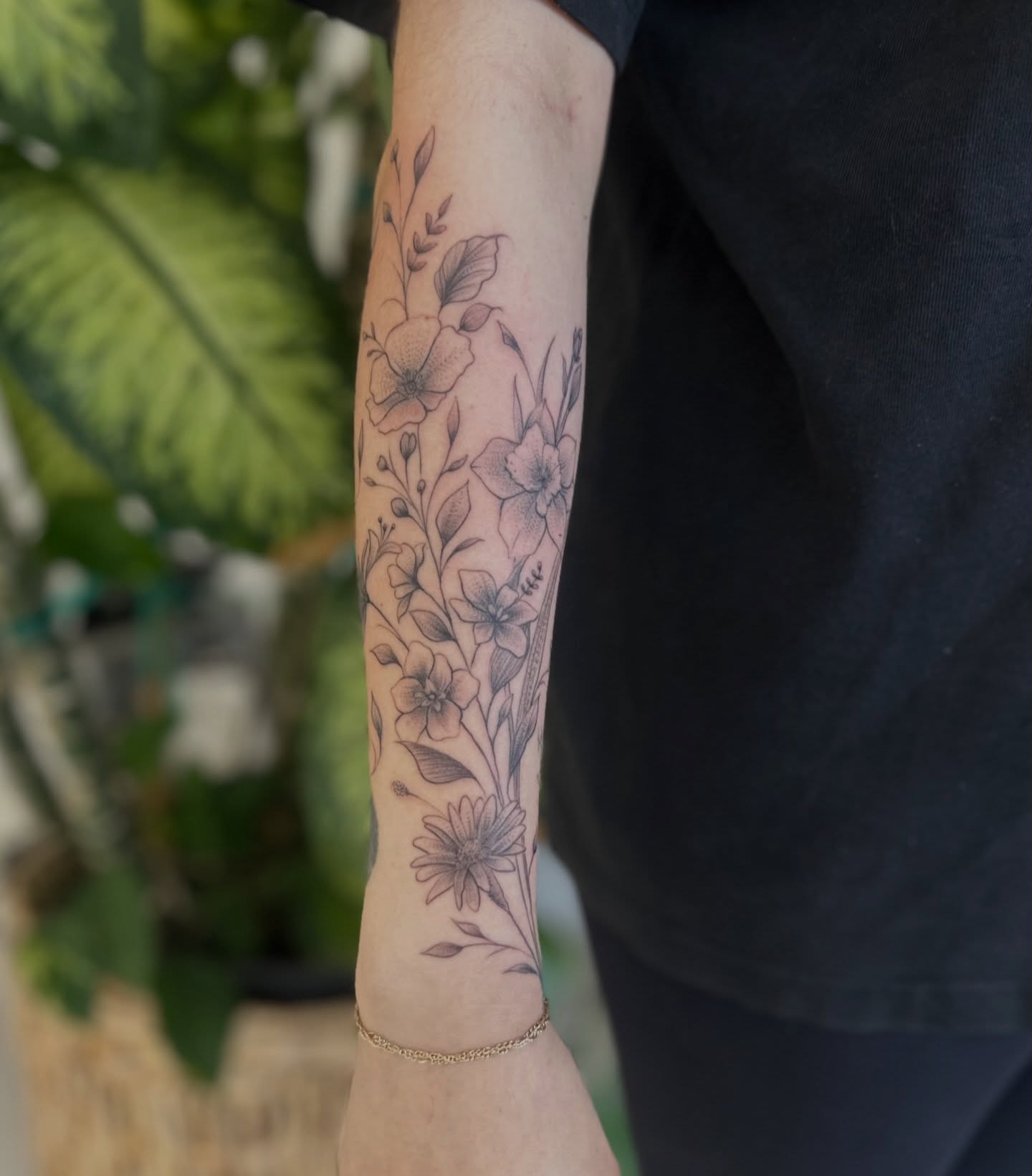 Floral arrangement black and grey tattoo on the forearm by Ric Castellon Tattoo Artist, Los Angeles, California