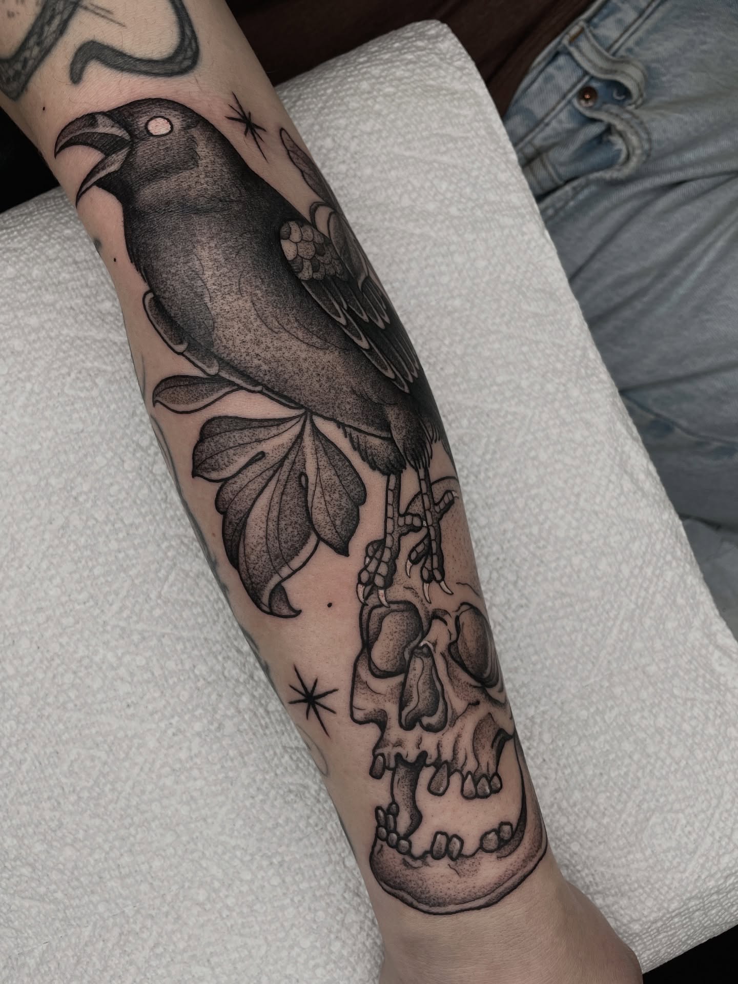 Crow and skulls American traditional tattoo on the forearm by Emily Lux