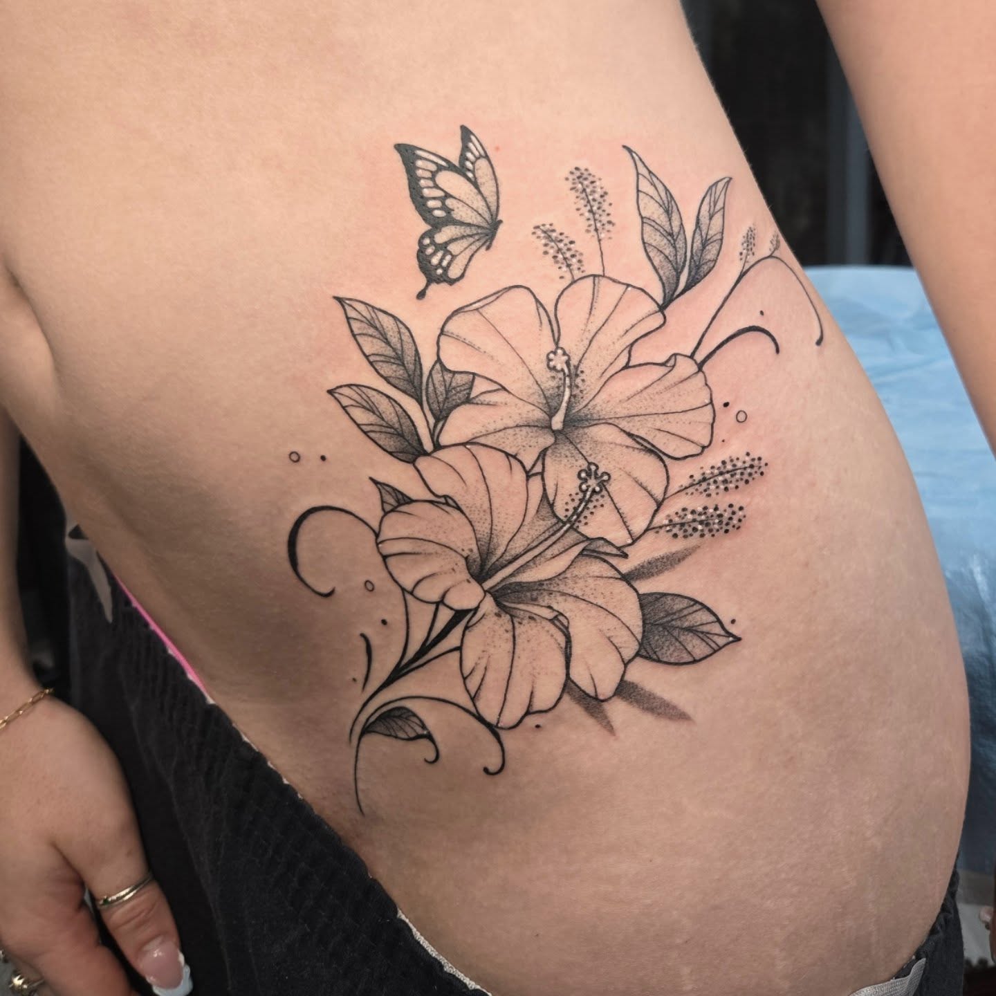 Hibiscus flowers and butterfly black and grey tattoo on the thigh by Britty Love, Nashville, Tennessee