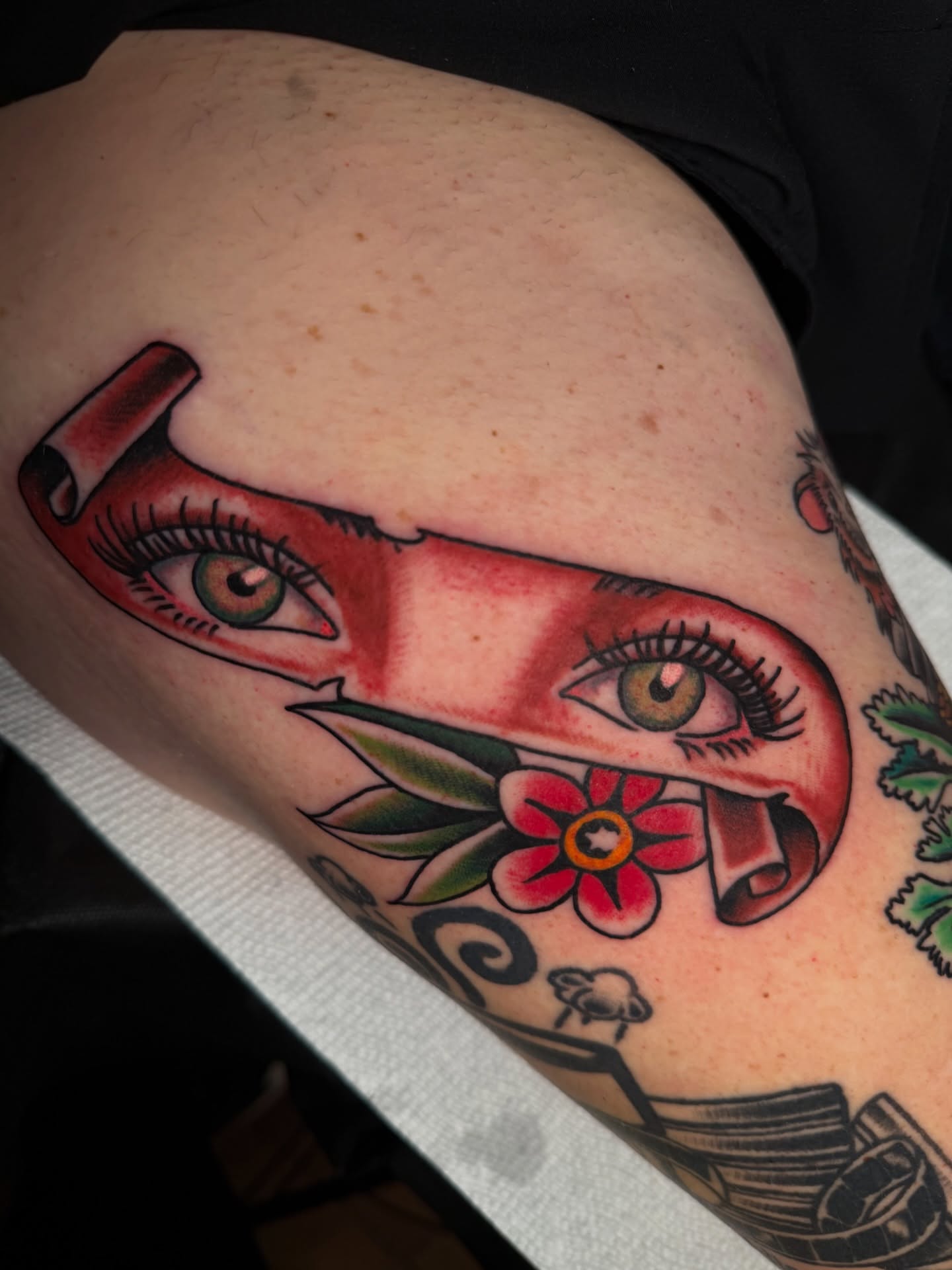 Eye and flower American traditional tattoo on the thigh by πππ’π―π’π¨ πππΆπ©π¬π―π, Manchester, New Hampshire