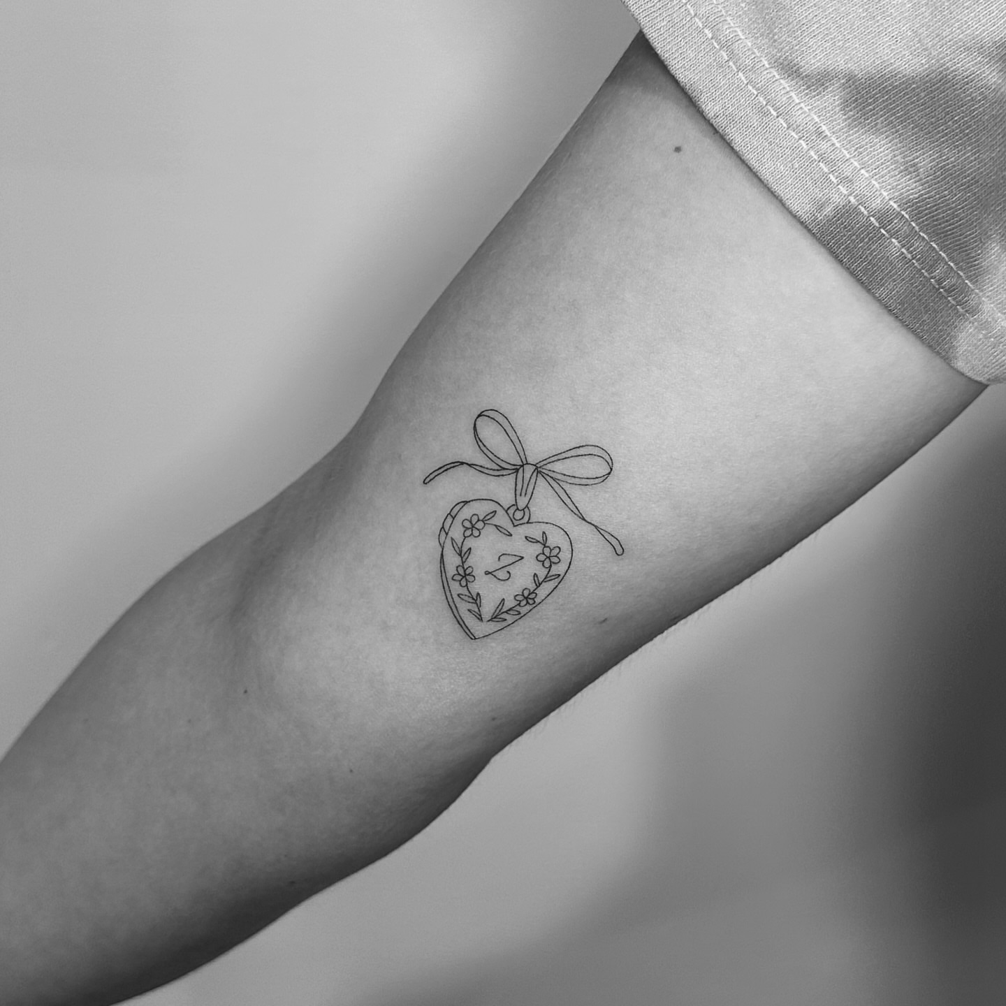 Heart with bow fine line tattoo on the forearm by Jessica, Cheektowaga, New York