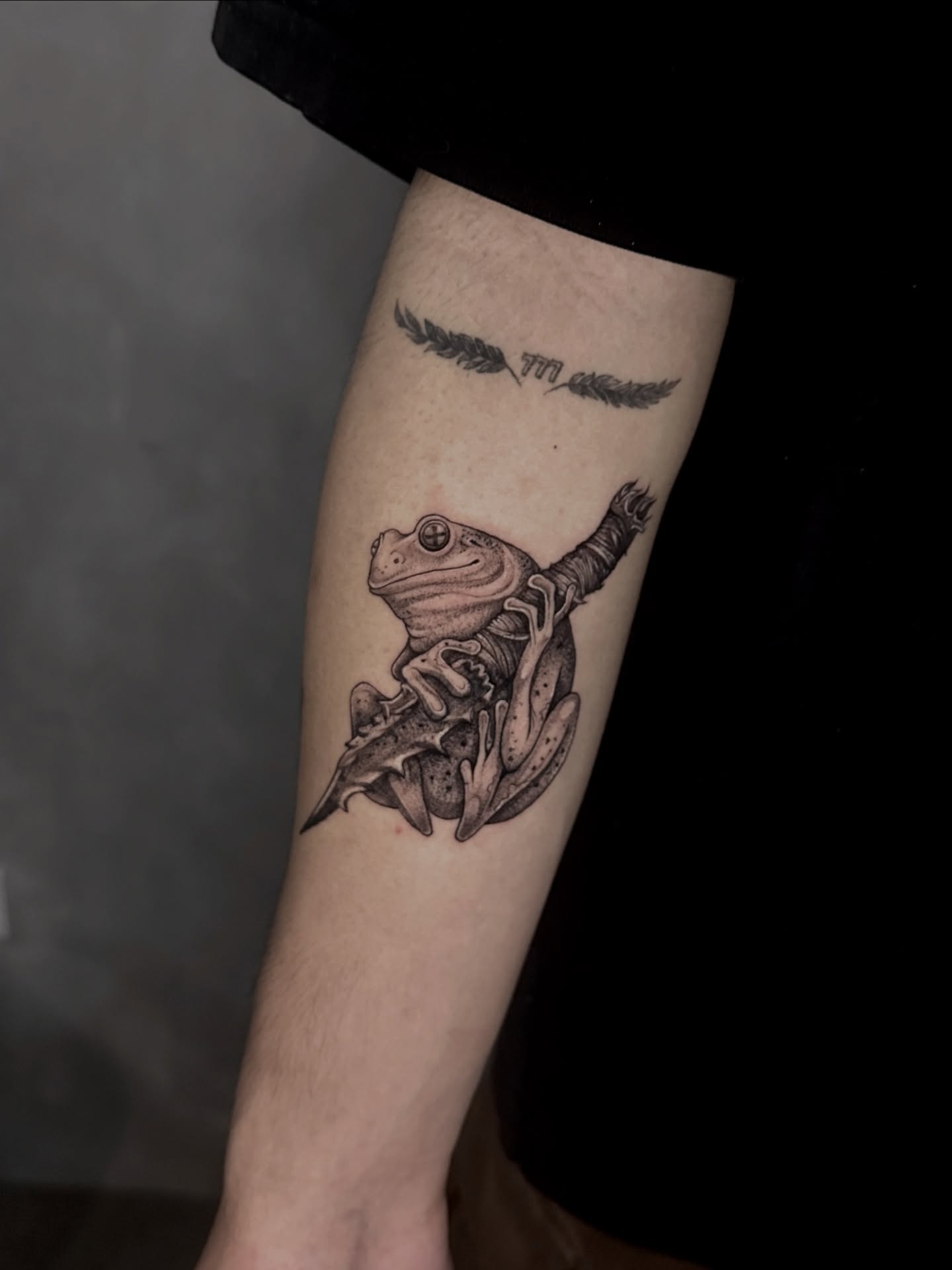 Frog and bird black and grey tattoo on the forearm by Arhem Quiambao