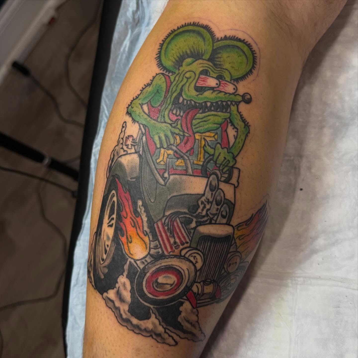Green rat driving car American traditional tattoo on the forearm by Matthew Gordon