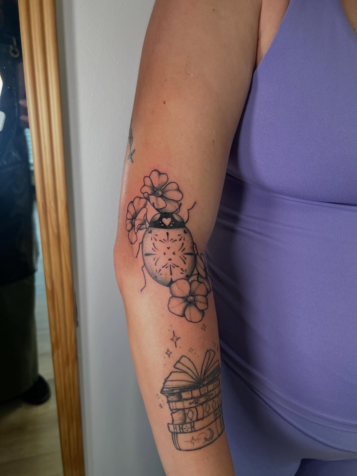 Book and flowers black and grey tattoo on the forearm by Presley Tattoos, Murfreesboro, Tennessee