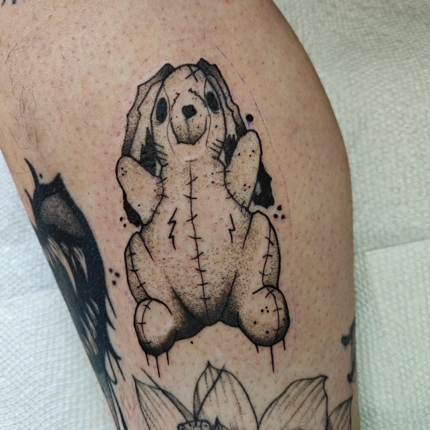 Stuffed animal black and grey tattoo on the thigh by Meg
