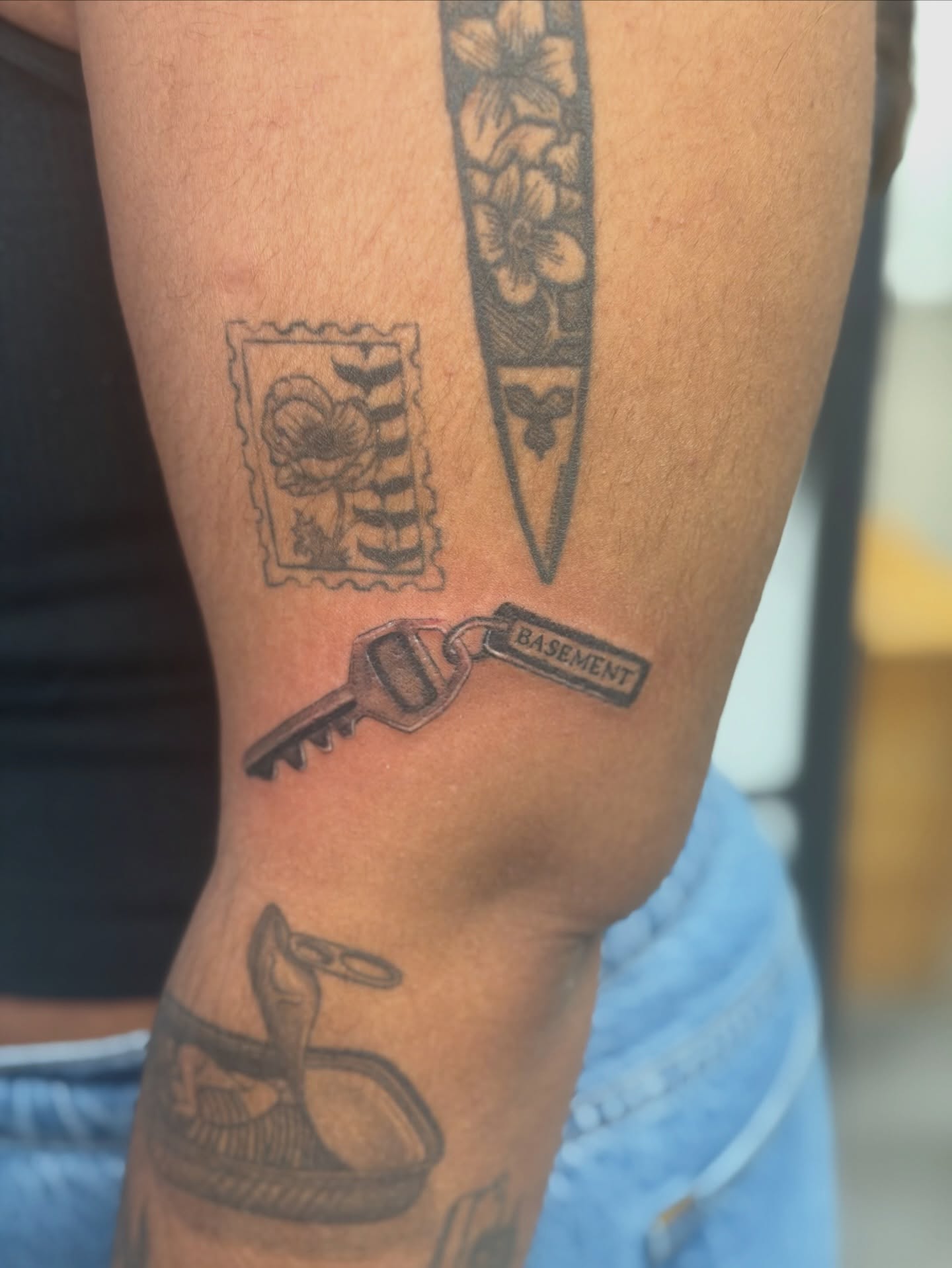 Key with 'basement' tag black and grey tattoo on the forearm by Alaska