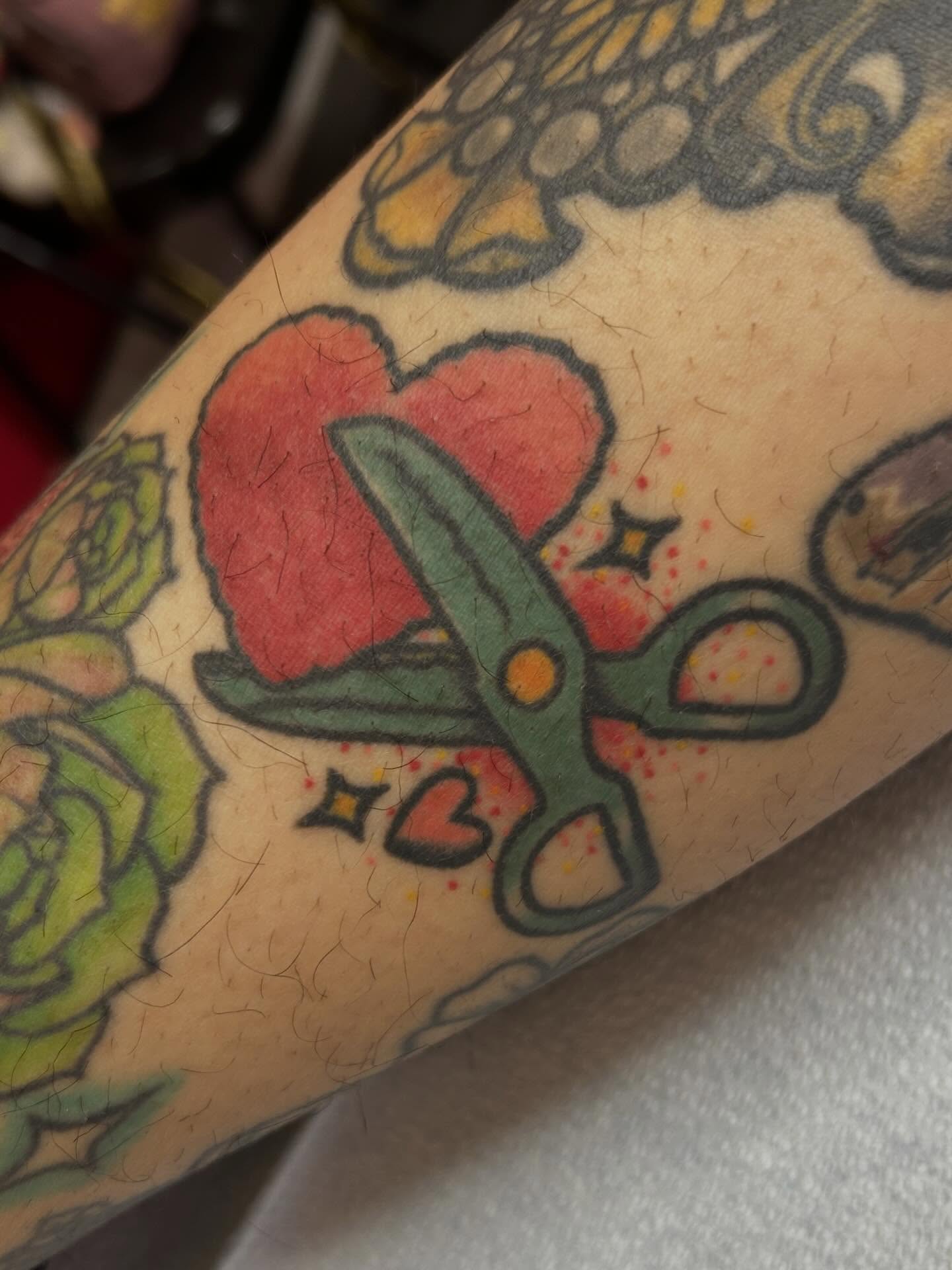 Scissors cutting heart American traditional tattoo on the forearm by Kelsey Lyons