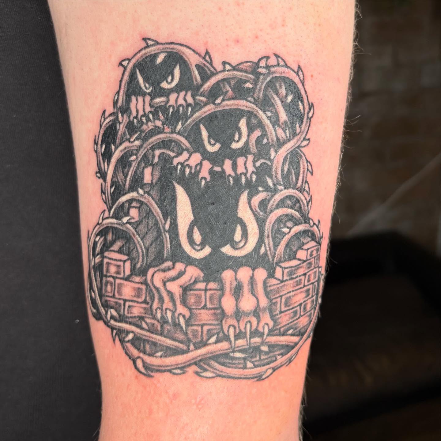 Monster black and grey tattoo on the forearm by Brendan Smith