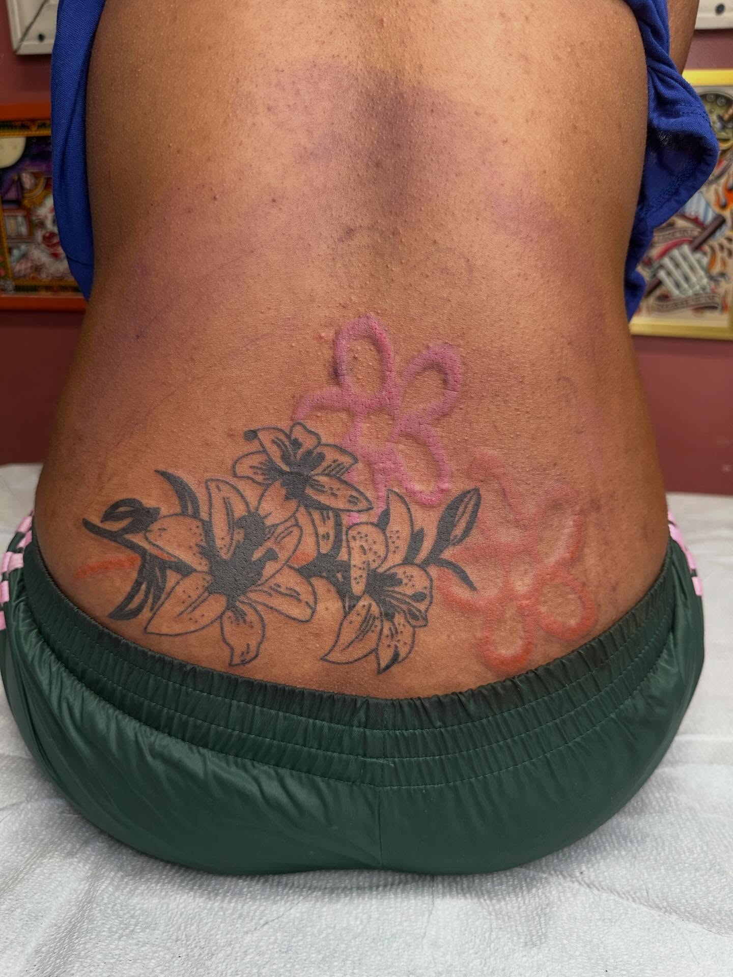 Lilies and ribbon black and grey tattoo on the torso by Alex Gunshefski