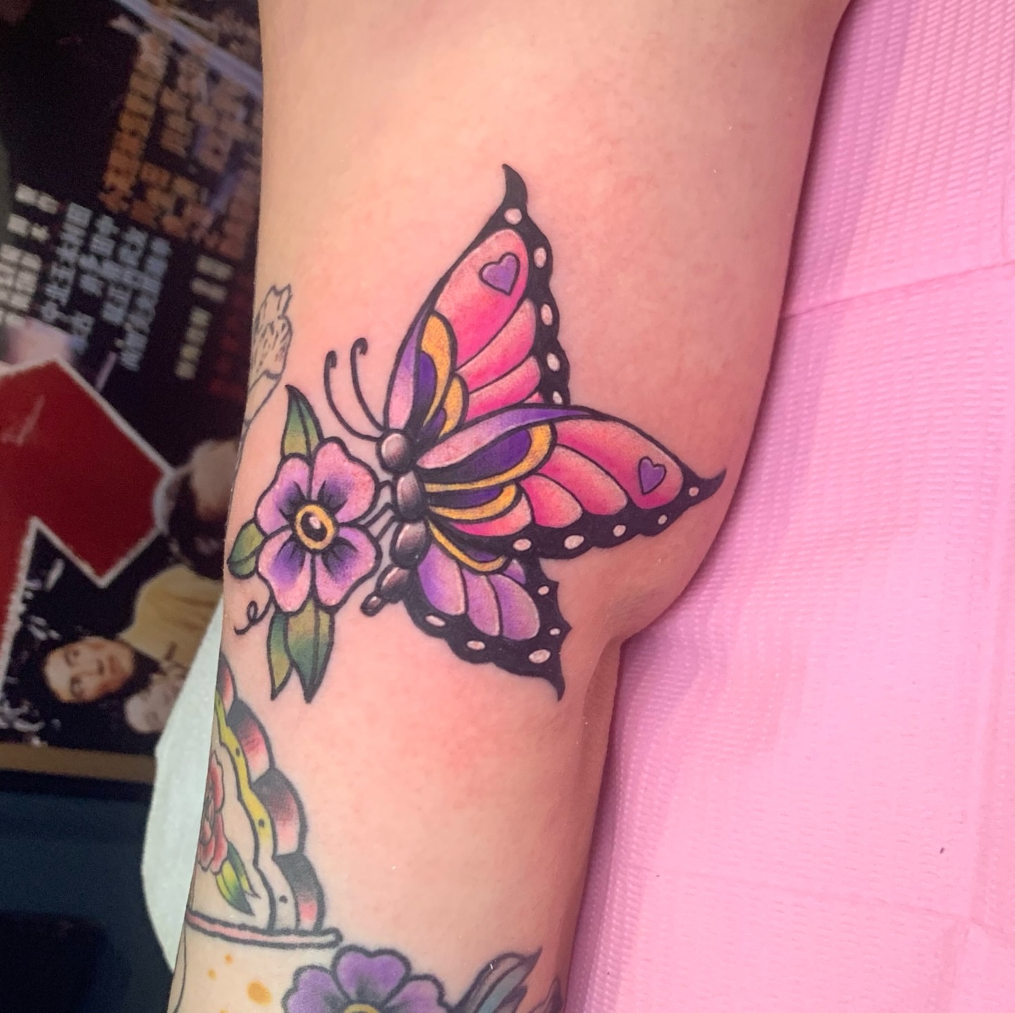 Butterfly and flower American traditional tattoo on the forearm by Aubrianna Grisez