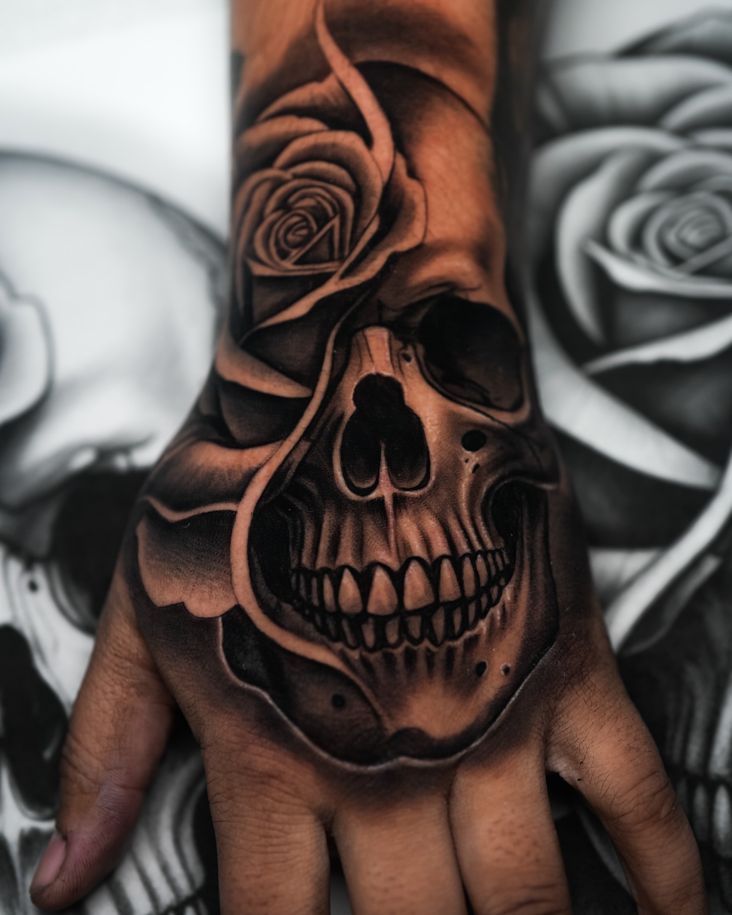 Skull and rose dark realism tattoo on the hand by Javier Chavez