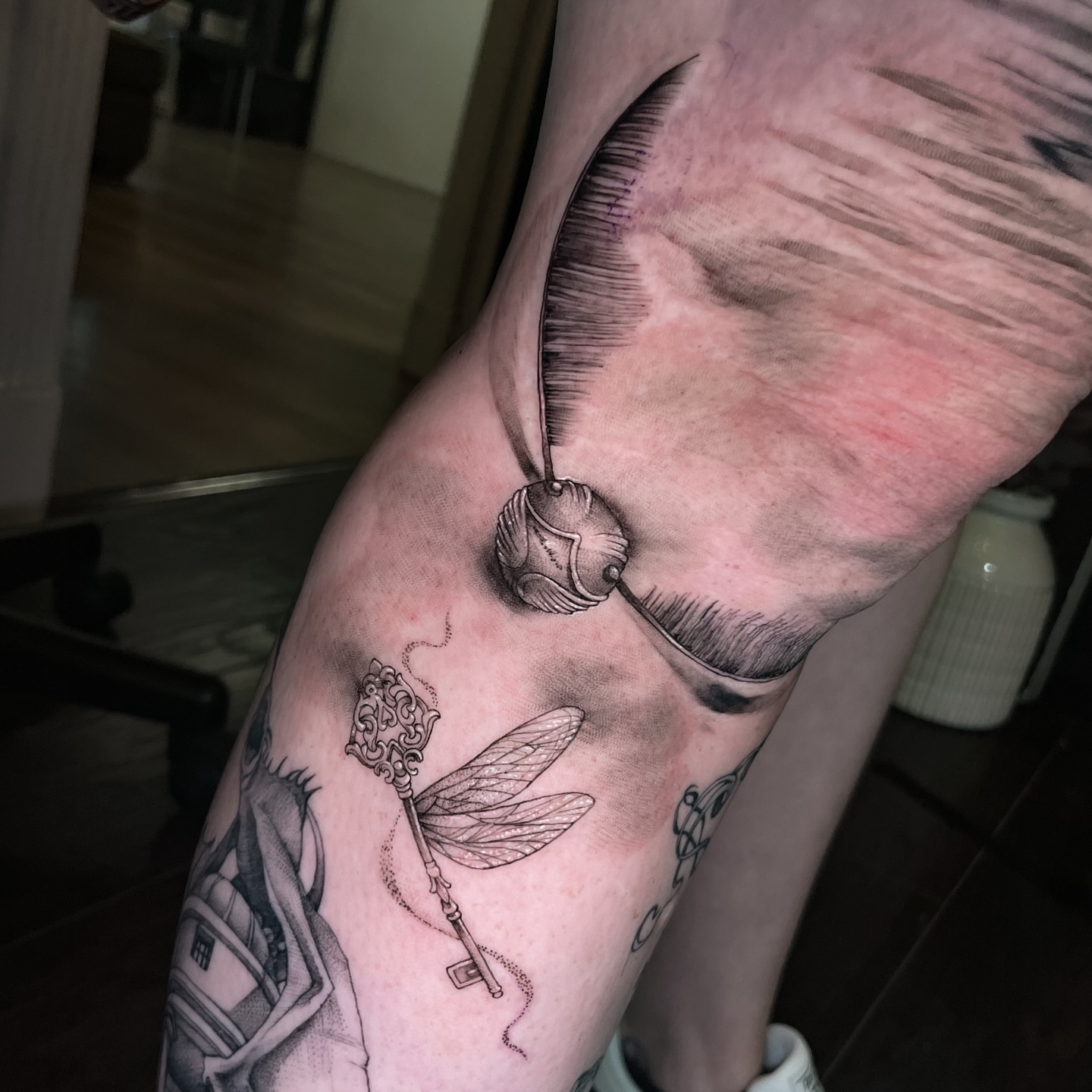 Key with dragonfly black and grey tattoo on the forearm by Erica Olivier