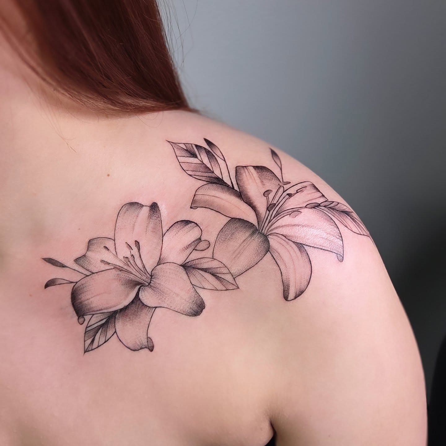 Lilies black and grey tattoo on the shoulder by Yvette Cebreros