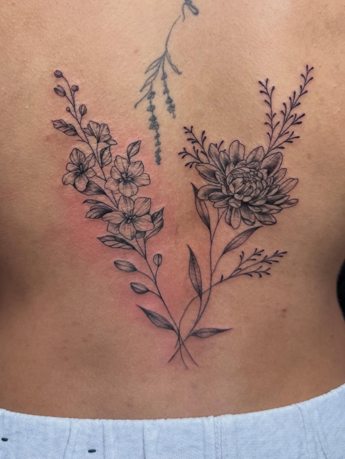 Floral arrangement black and grey tattoo on the ribs by Imani