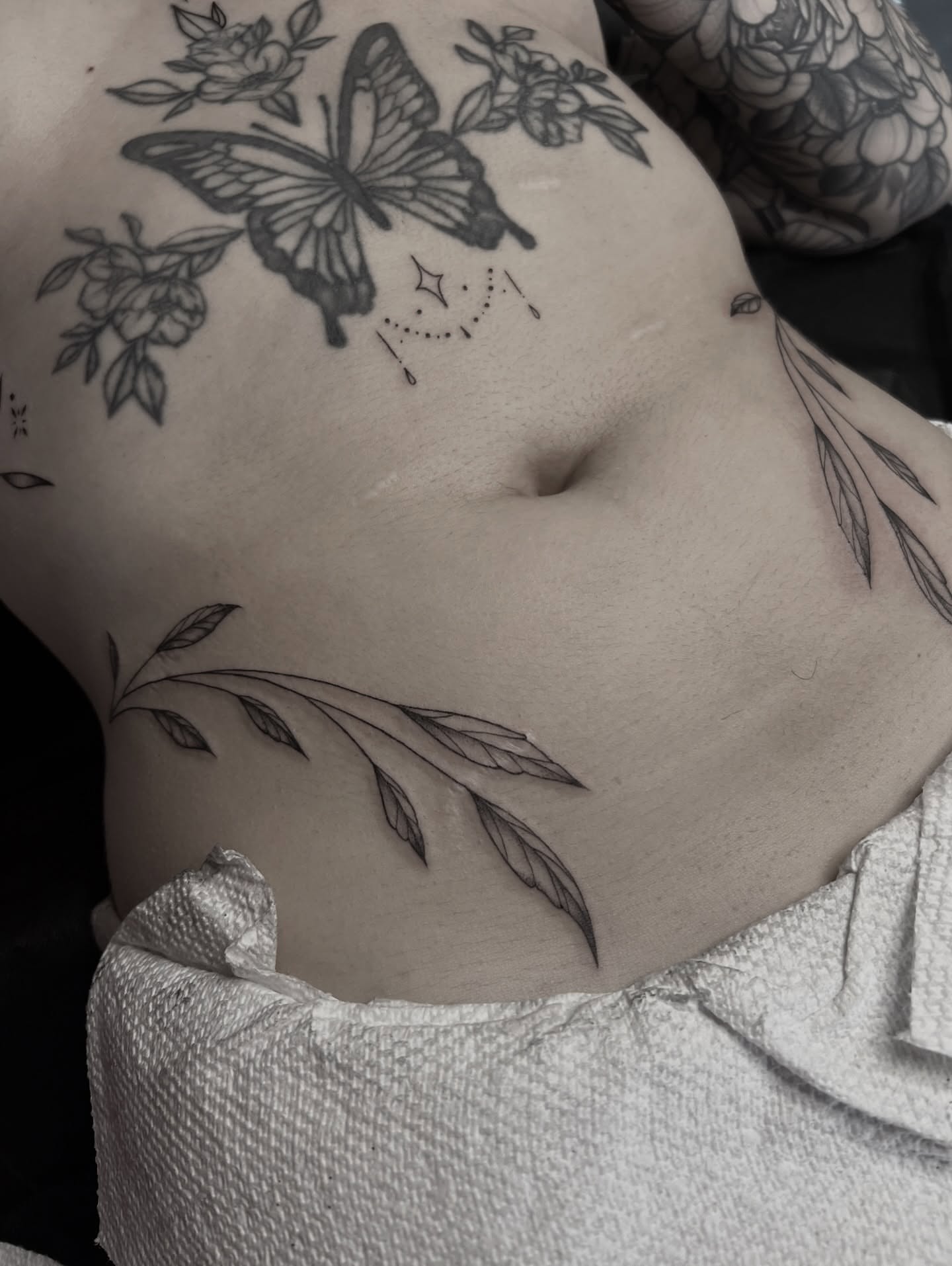 Butterfly and floral black and grey tattoo on the torso by ✶ H A N N A H K A y ✶