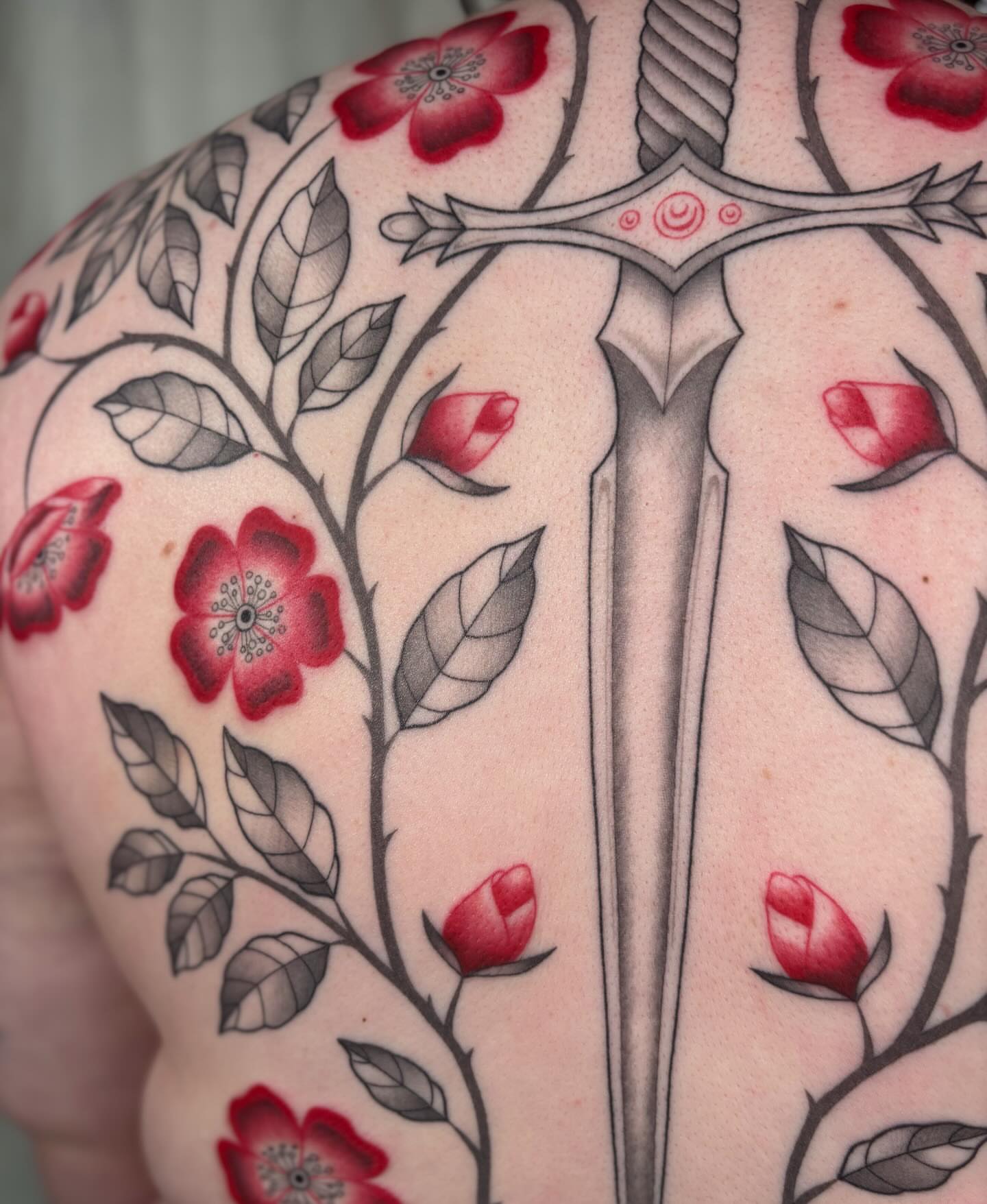 Sword and cherry blossoms neo-traditional tattoo on the shoulder by Anna Sage