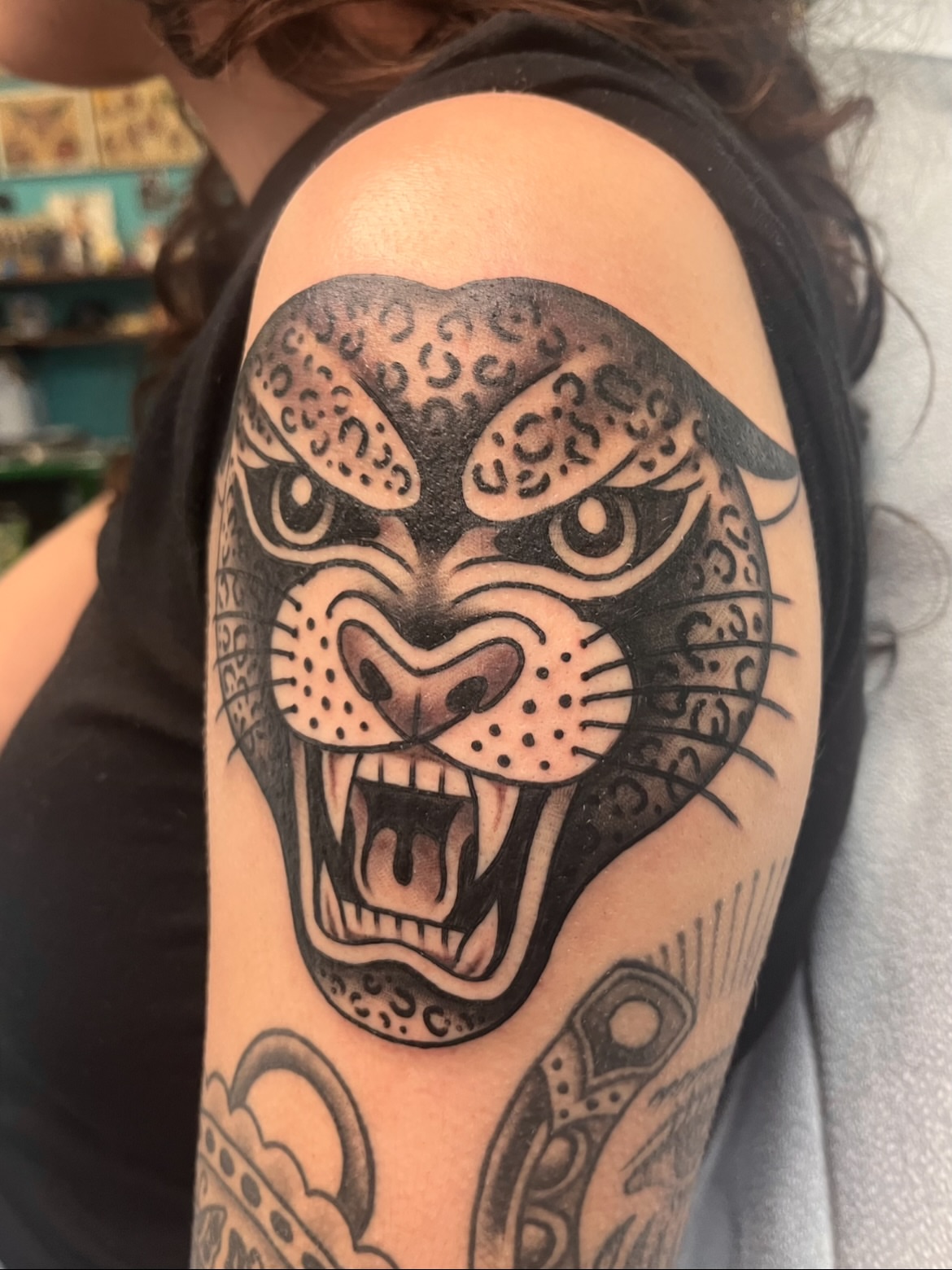 Panther American traditional tattoo on the upper arm by Macy Bird
