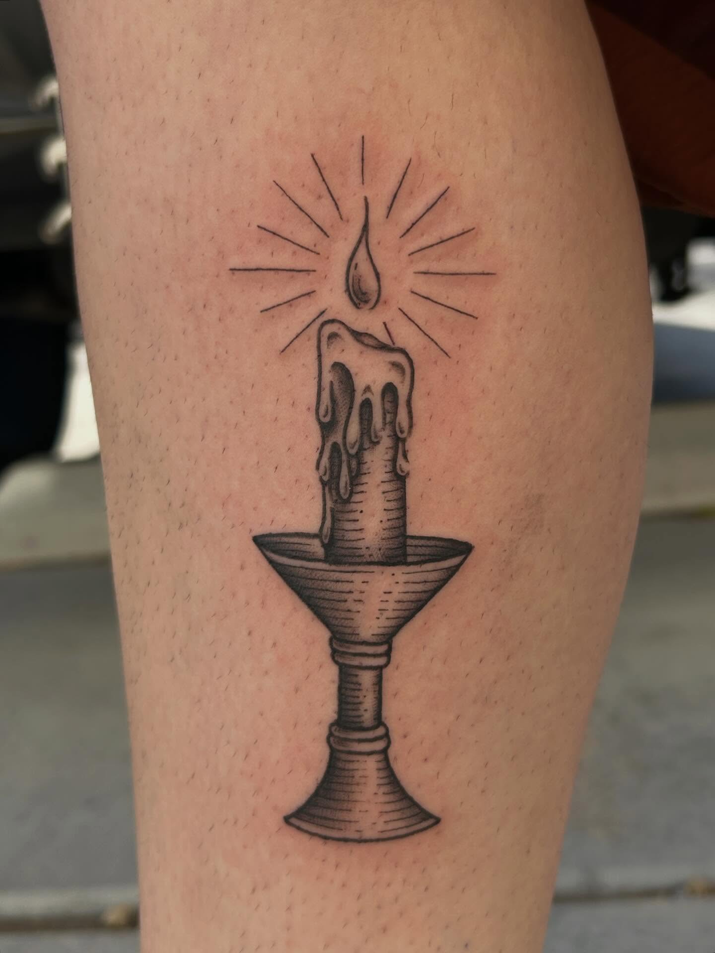 Candle black and grey tattoo on the thigh by Janelle McCarthy