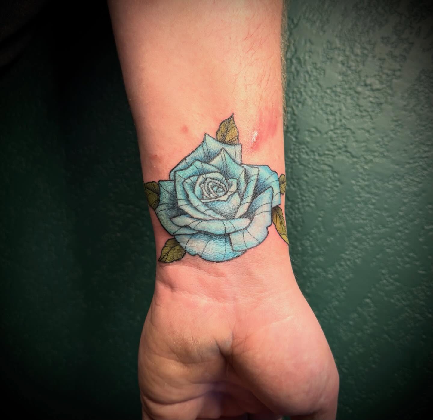 Blue rose realism tattoo on the forearm by Shelly Elissa Tattoos